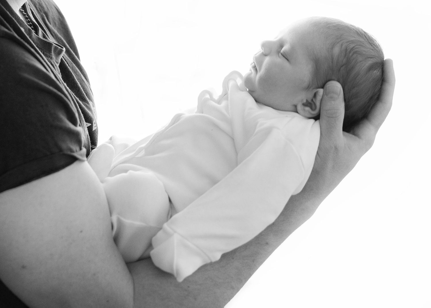Black and white series showing tender moments between parent and newborn.