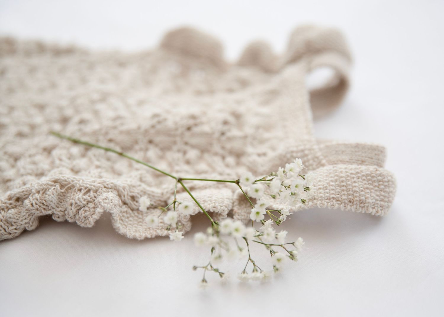 Romantic composition of lace trim and delicate baby's breath flowers on neutral background.