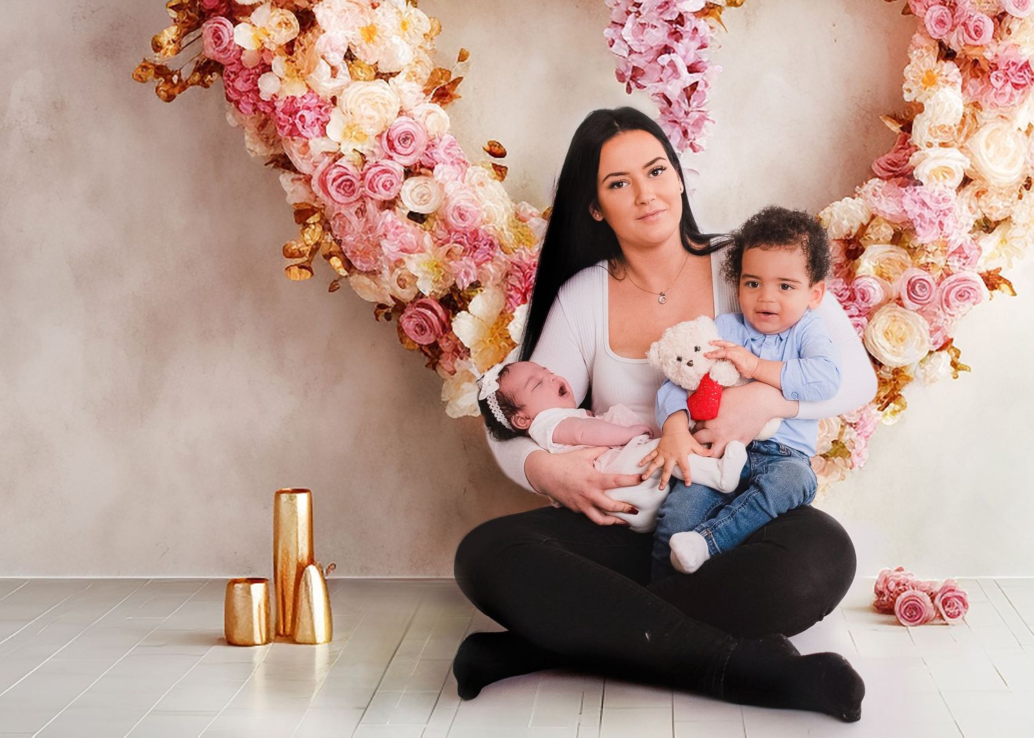 Studio portrait setup with pink floral arrangements and soft lighting against a neutral backdrop.