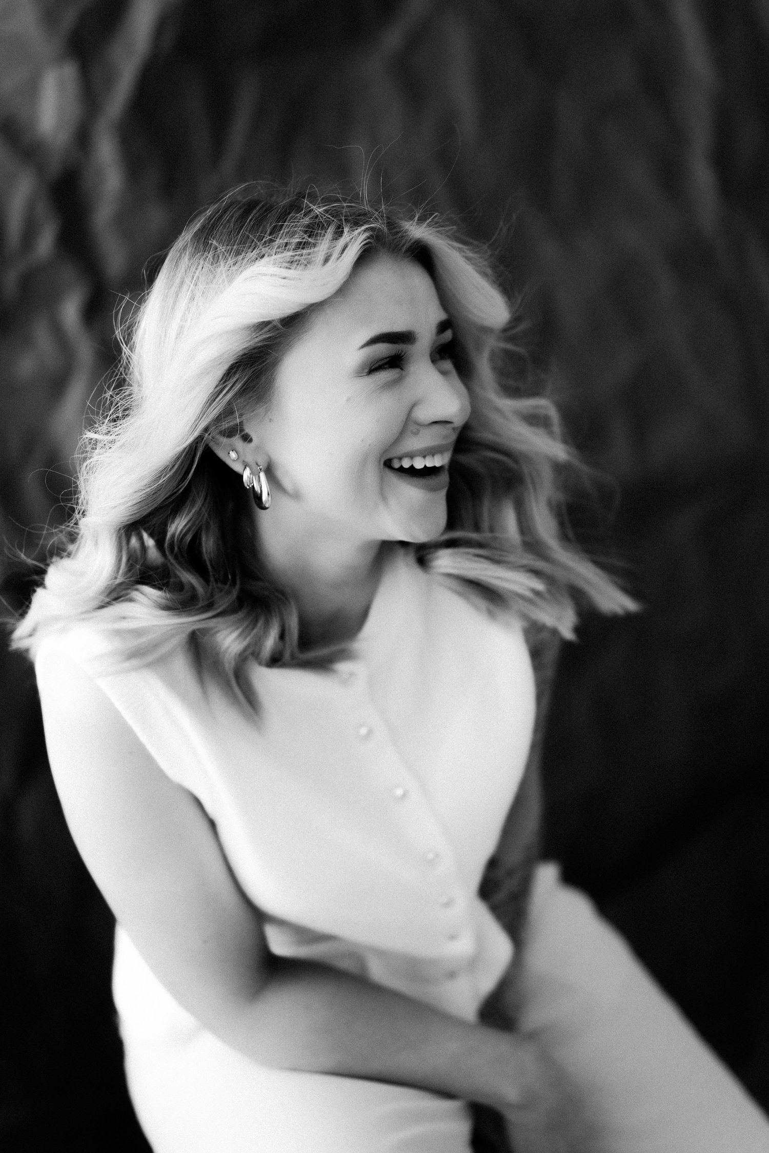 A sequence of black and white photographs showing joyful laughter and movement in a candid portrait series.
