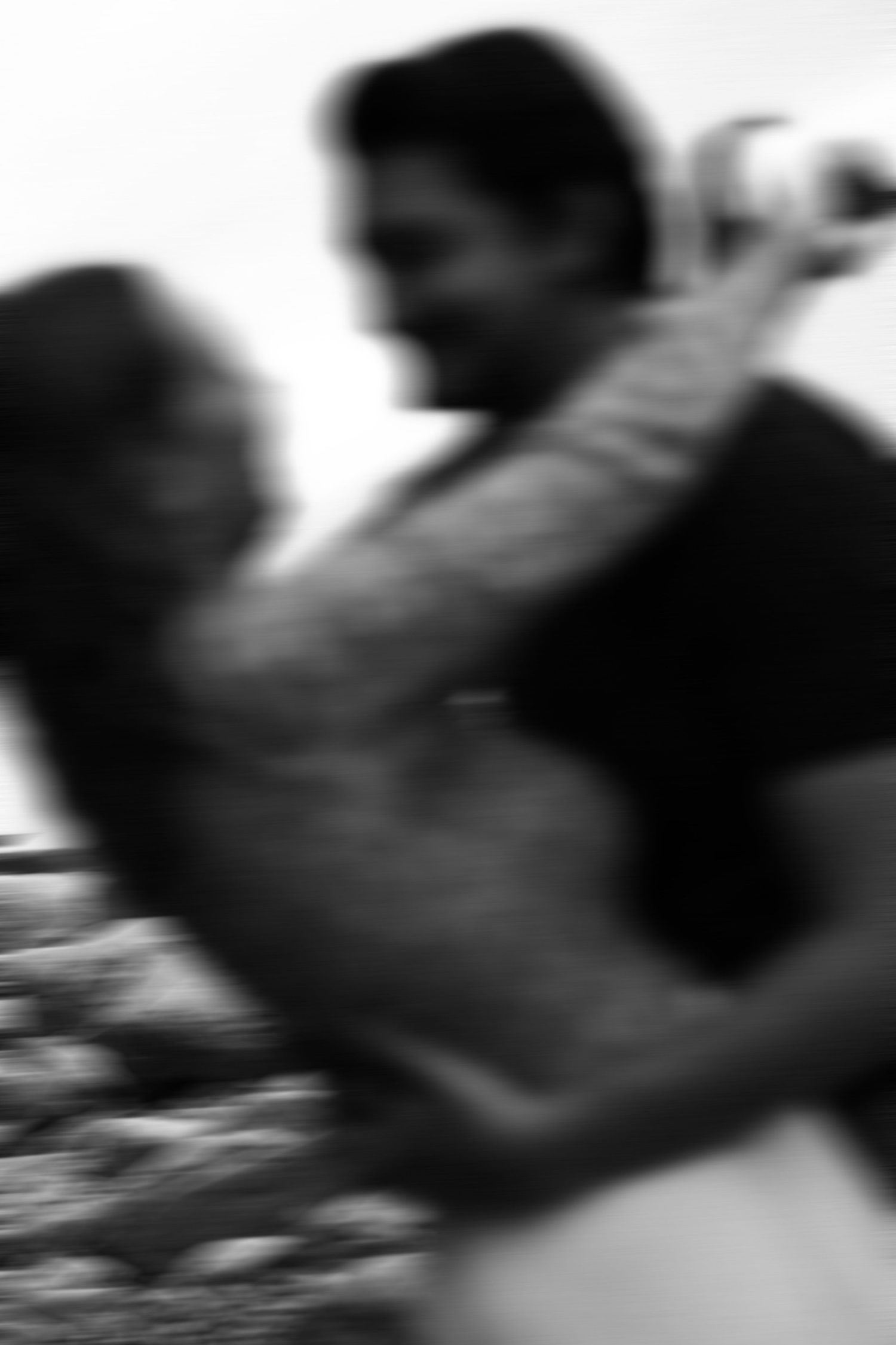 A blurred black and white motion photograph of dancers in an intimate embrace.