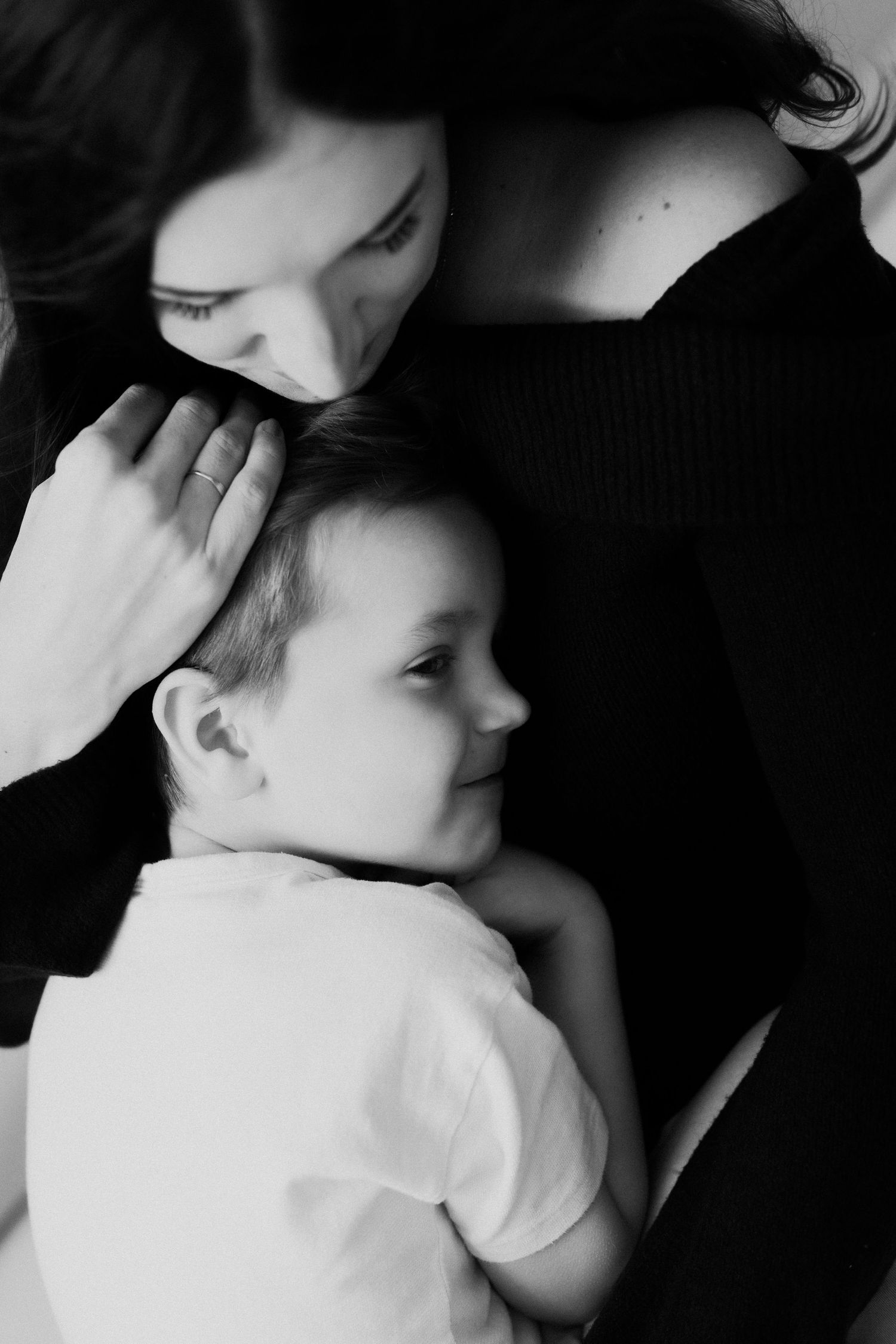 Black and white photo series showing tender moments of a parent cradling and comforting their sleeping baby.
