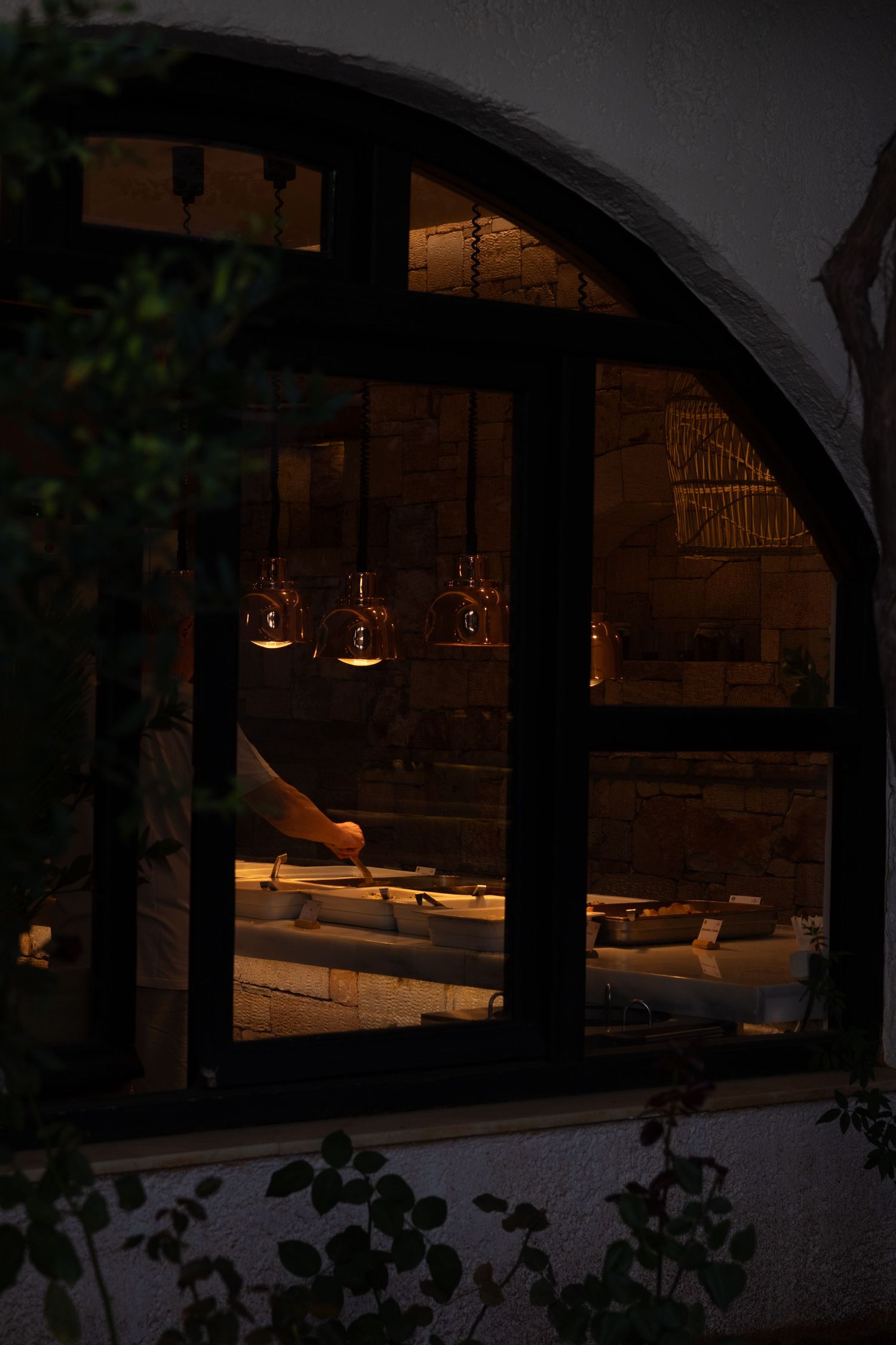 Dimly lit arched interior space with lounge seating and ambient lighting.