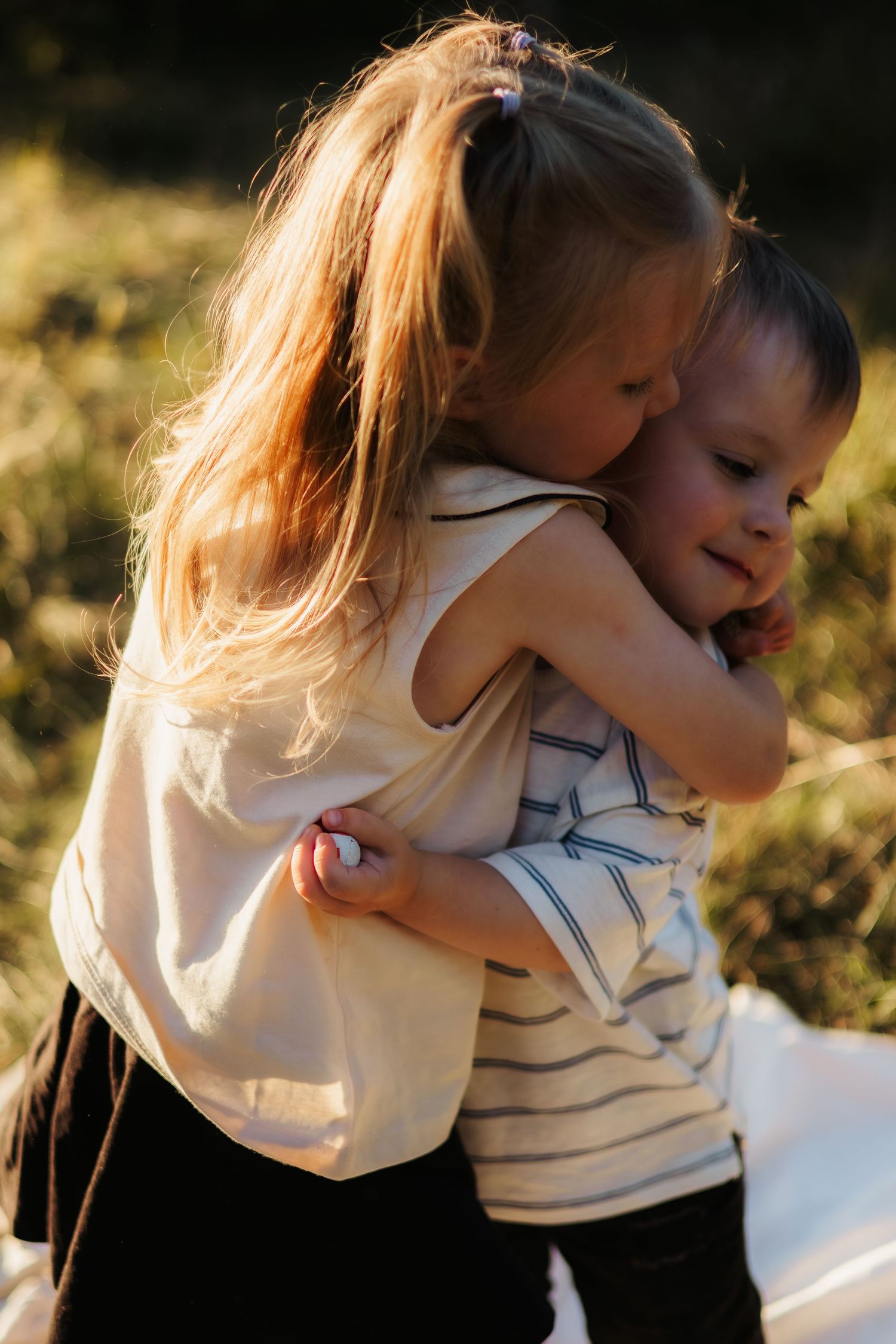 Two children sharing a warm embrace in a series of candid moments captured in natural light.