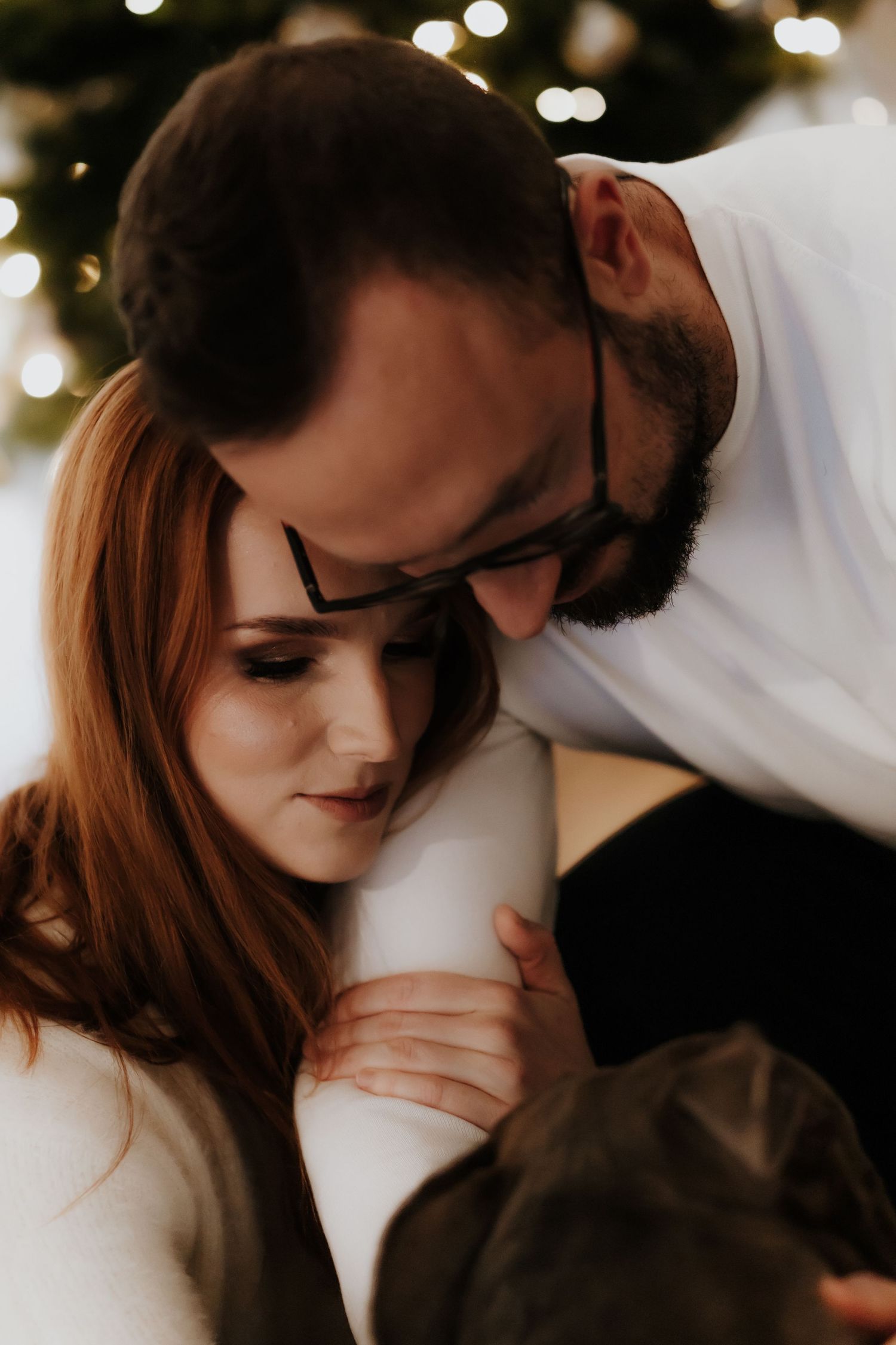 A romantic couple shares intimate moments in a series of soft-lit photos with bokeh lights in the background.