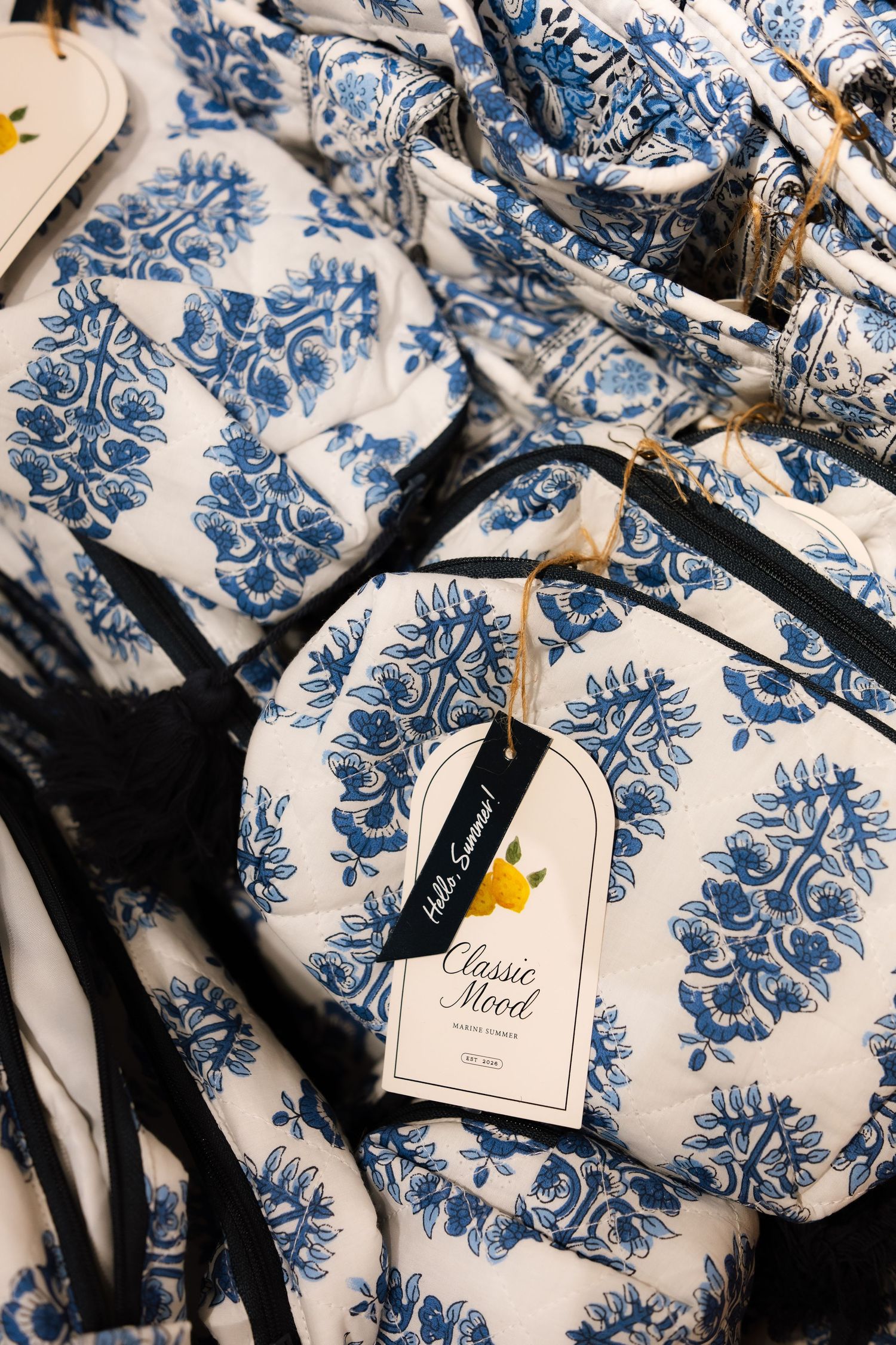 White and blue damask pattern fabric with hanging gift tags creates an elegant wedding favor display.