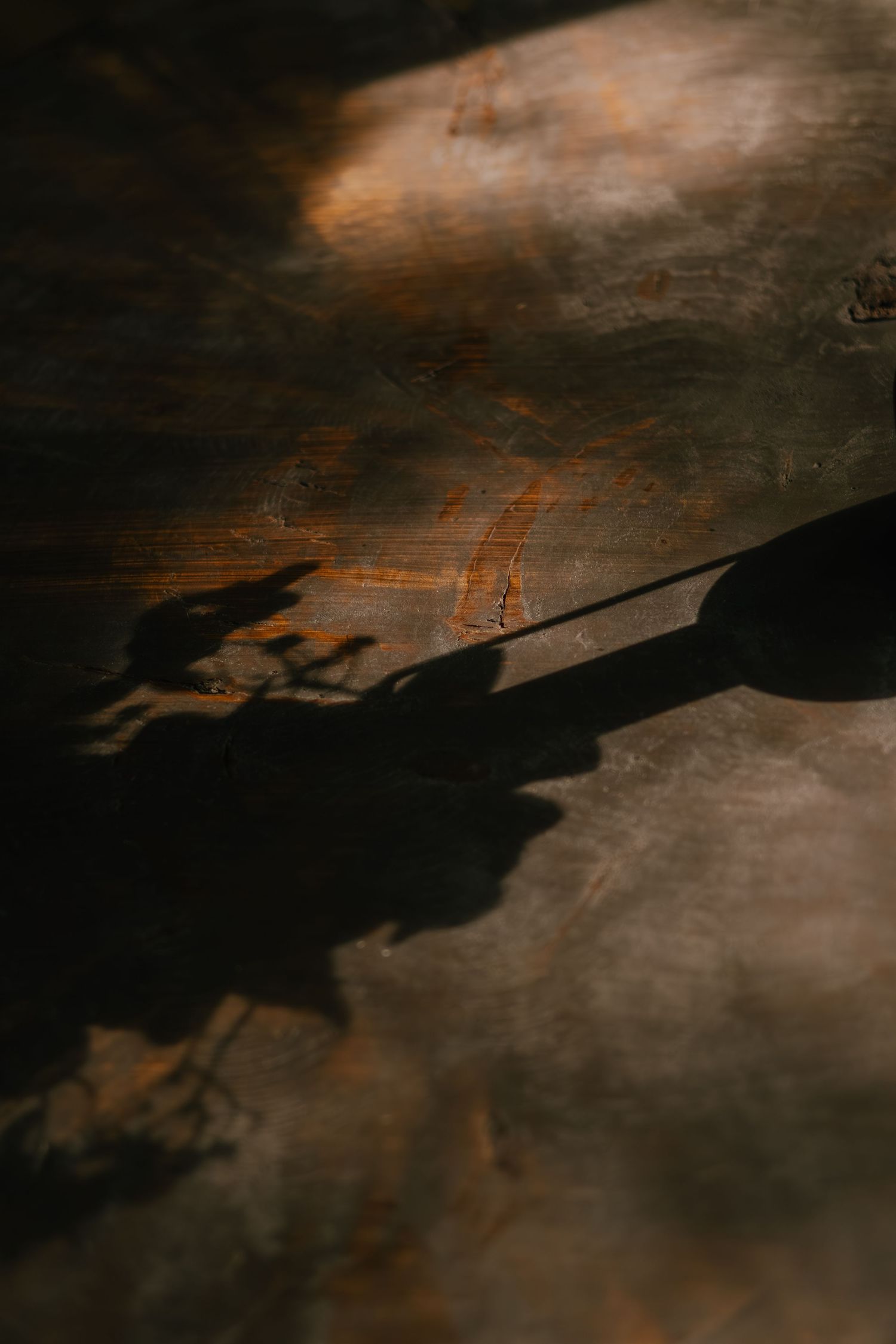 Abstract dark background with shadowy textures and subtle orange highlights creating a moody atmospheric effect.