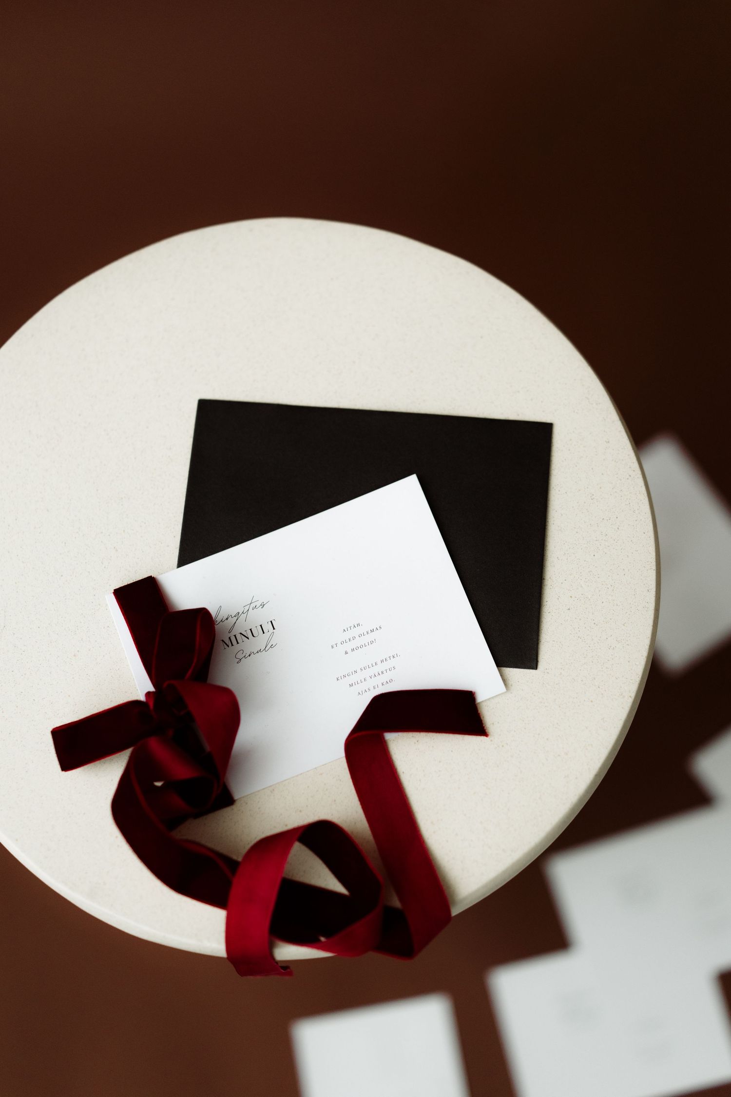 A series of white oval shapes with dark shadows and red ribbons creating an artistic composition against a dark background.