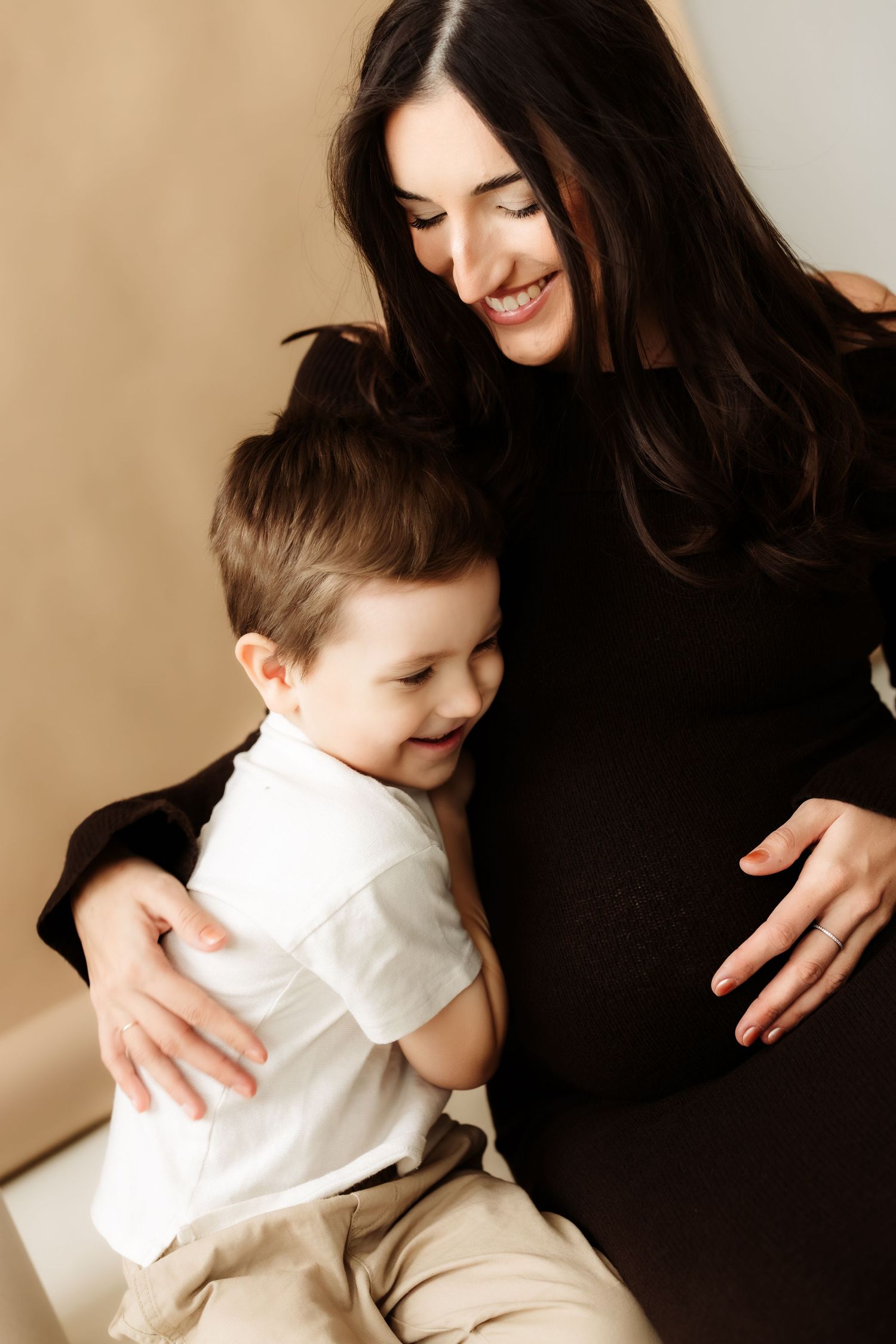 A tender moment captured in a series of photos showing parent and child in black and white clothing embracing warmly.