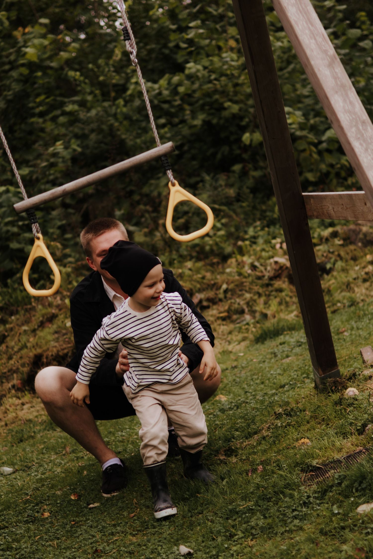 A sequence of playful moments in a backyard garden with gymnastic rings hanging from wooden beams.