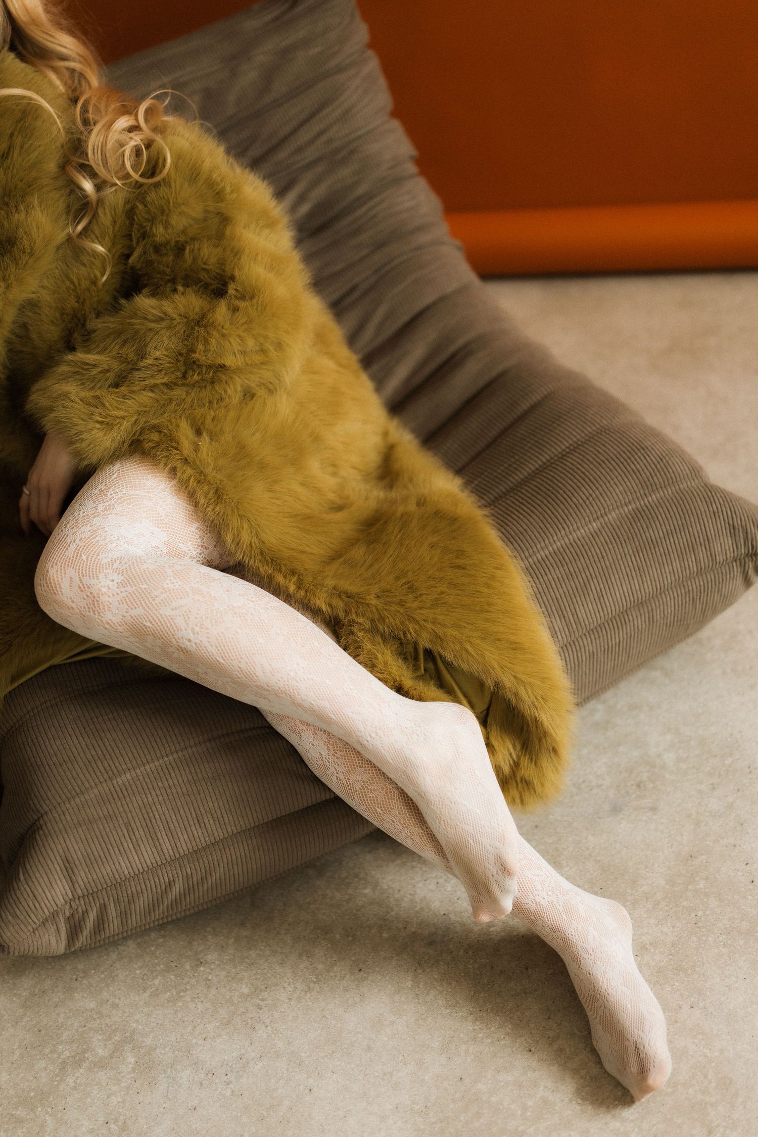 A sequence of images showing a foot in a white sock gradually emerging from beneath a brown cushion or pillow.