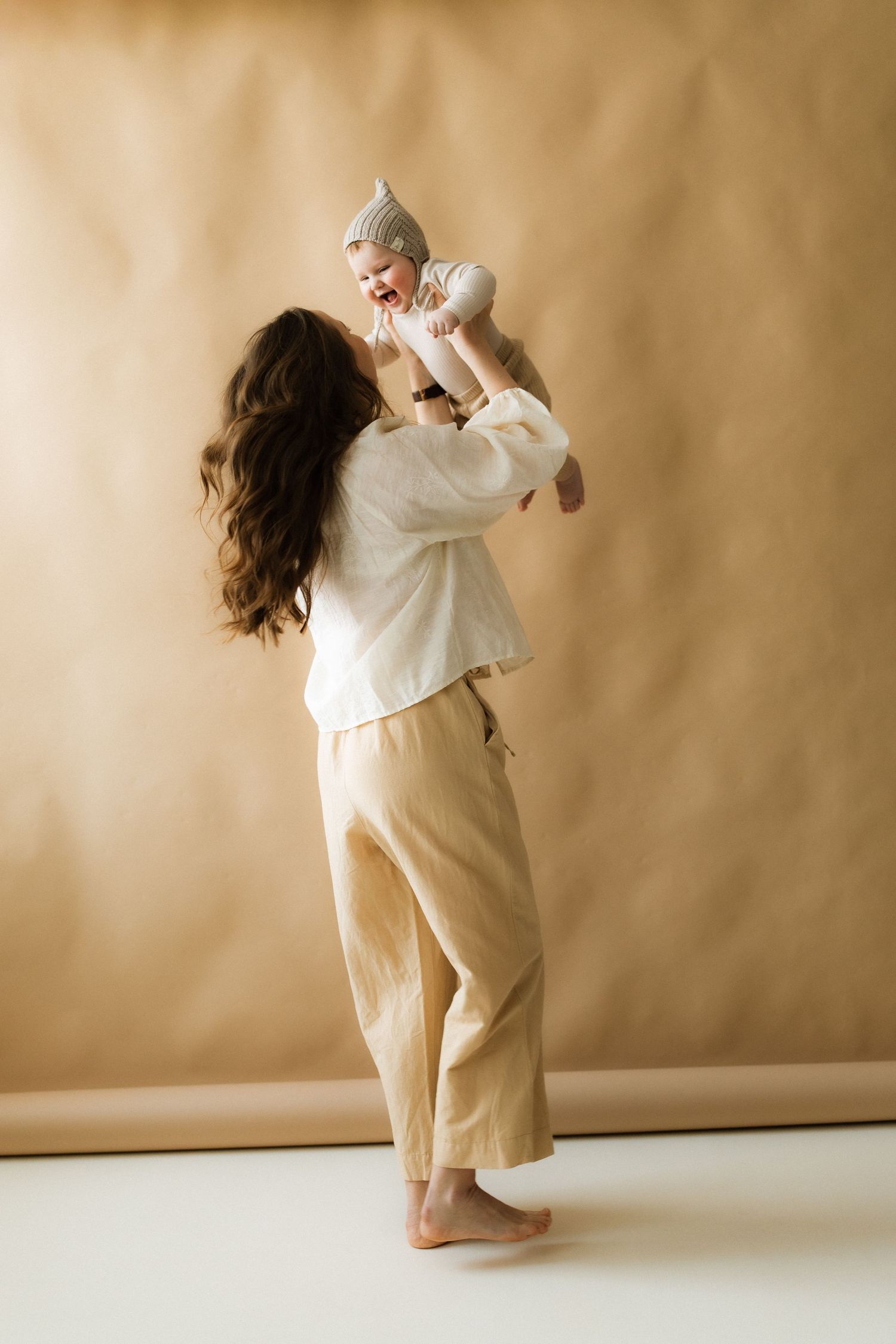A sequence of dance movements in beige tones showing a flowing white garment against a neutral background.