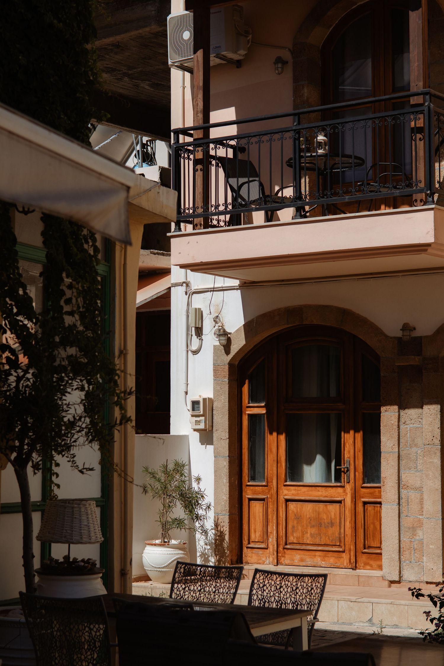 Mediterranean style building exterior with wooden doors and balcony details.