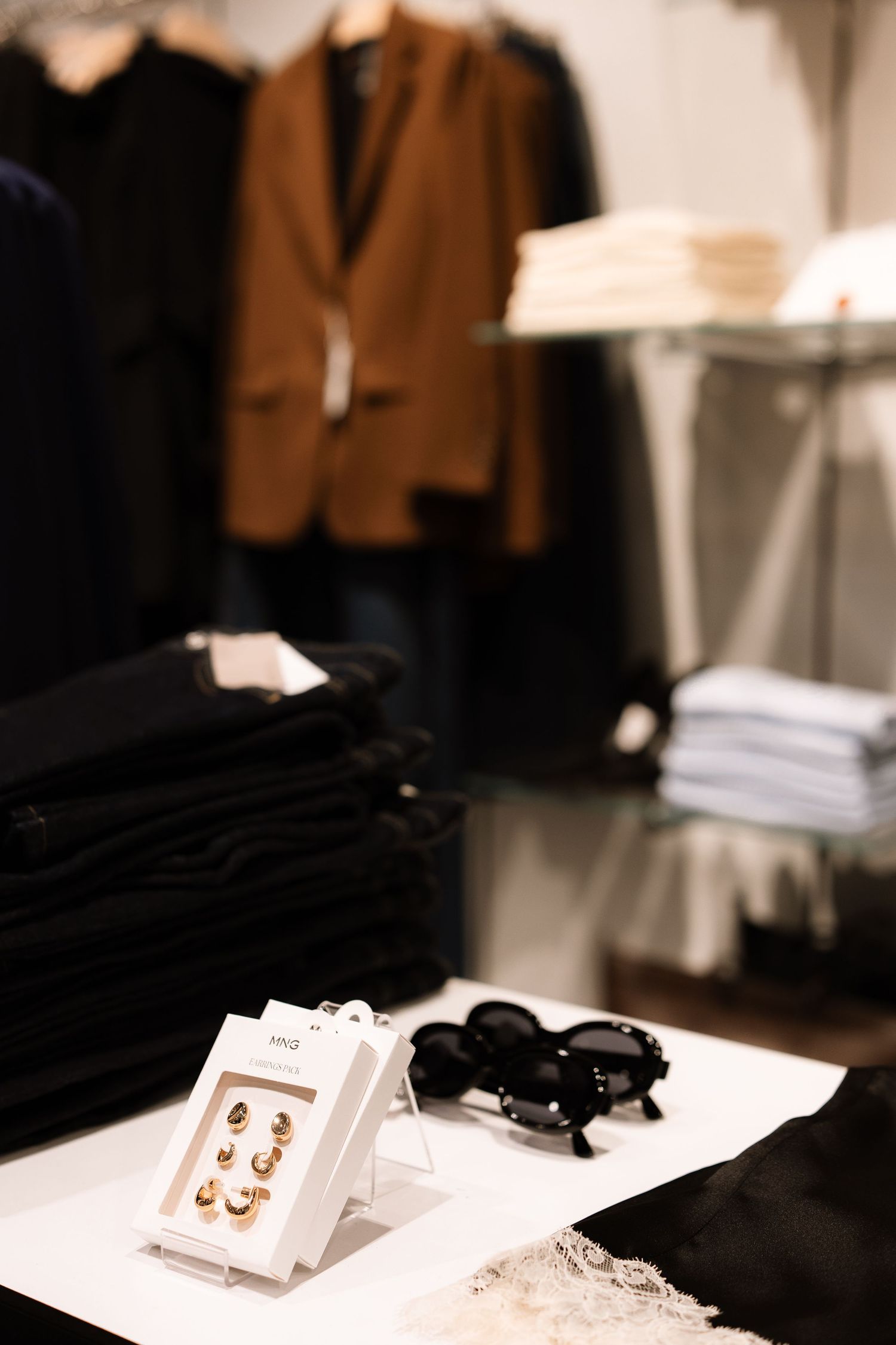 Jewelry and fashion accessories displayed in a retail store with elegant lighting and minimalist presentation.