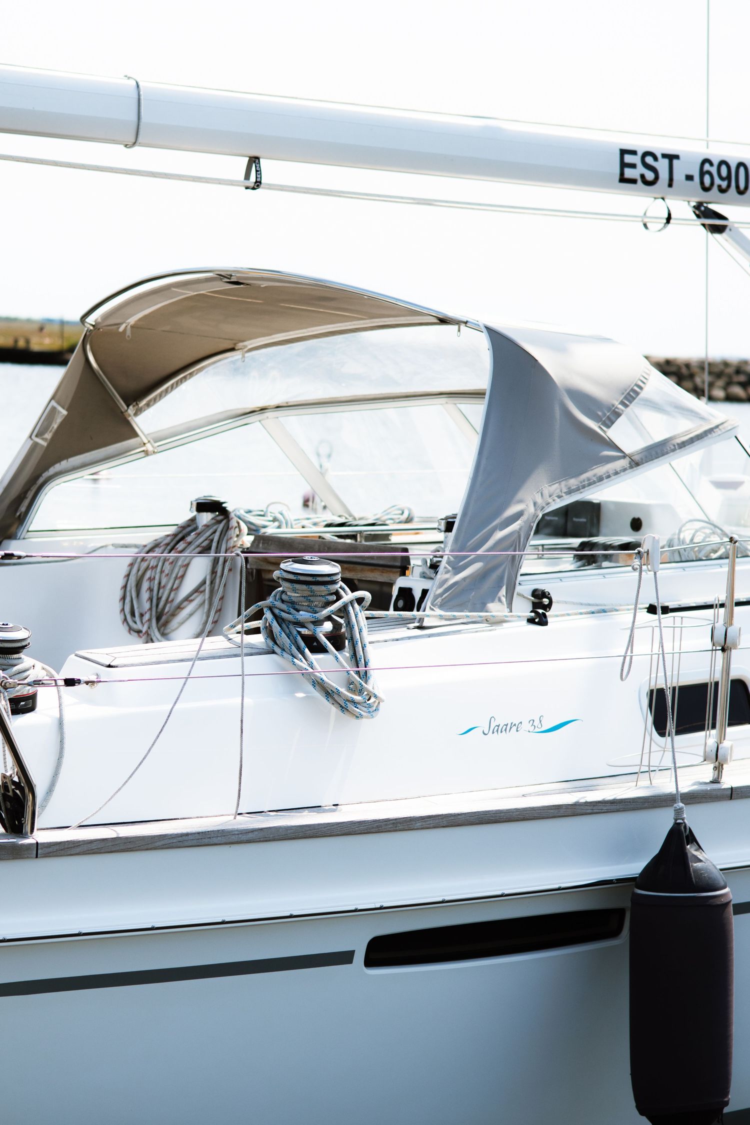 White sailboats docked at a marina with sleek modern designs and fiberglass hulls.