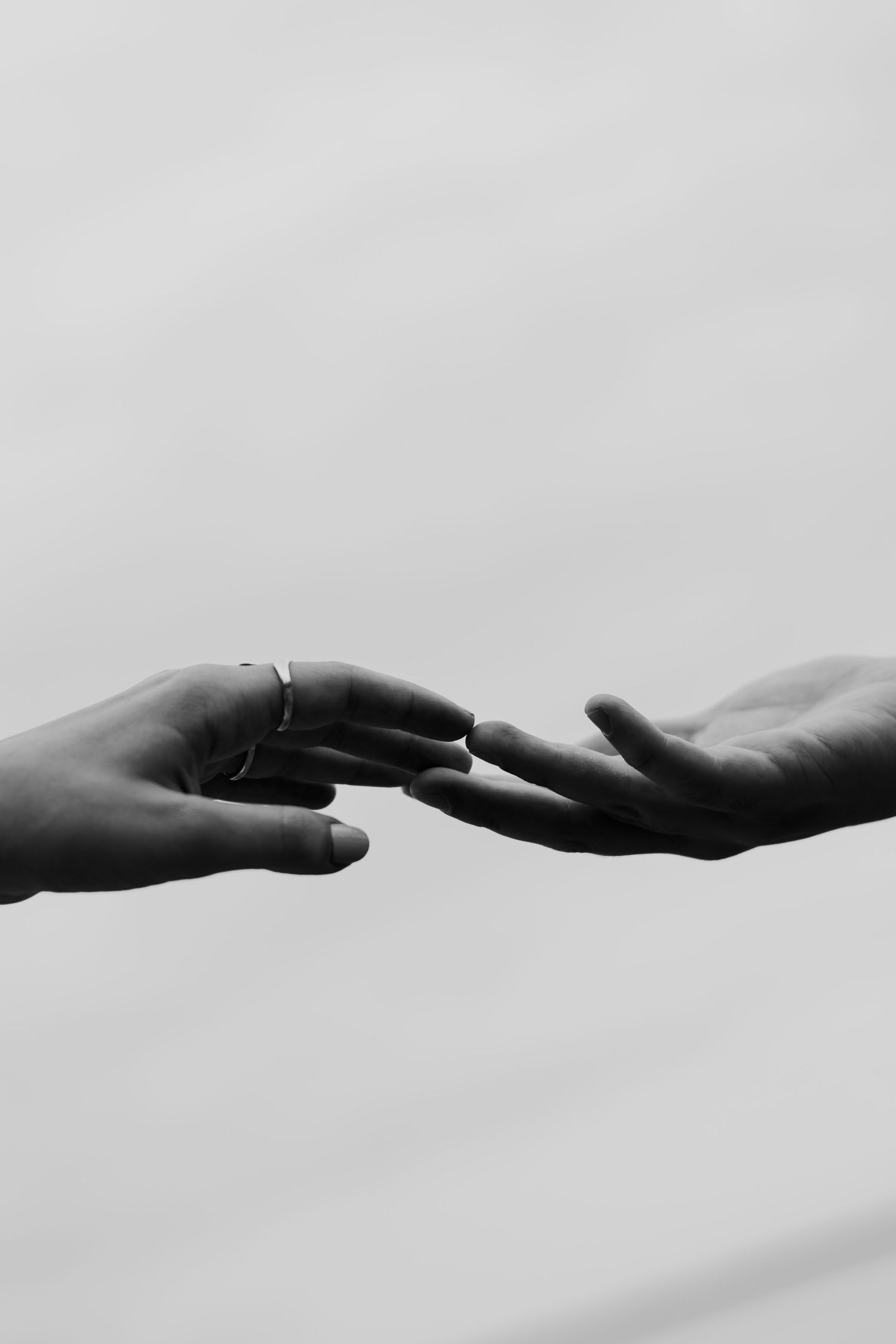 A black and white photo series showing hands reaching towards each other in a sequence of connection.