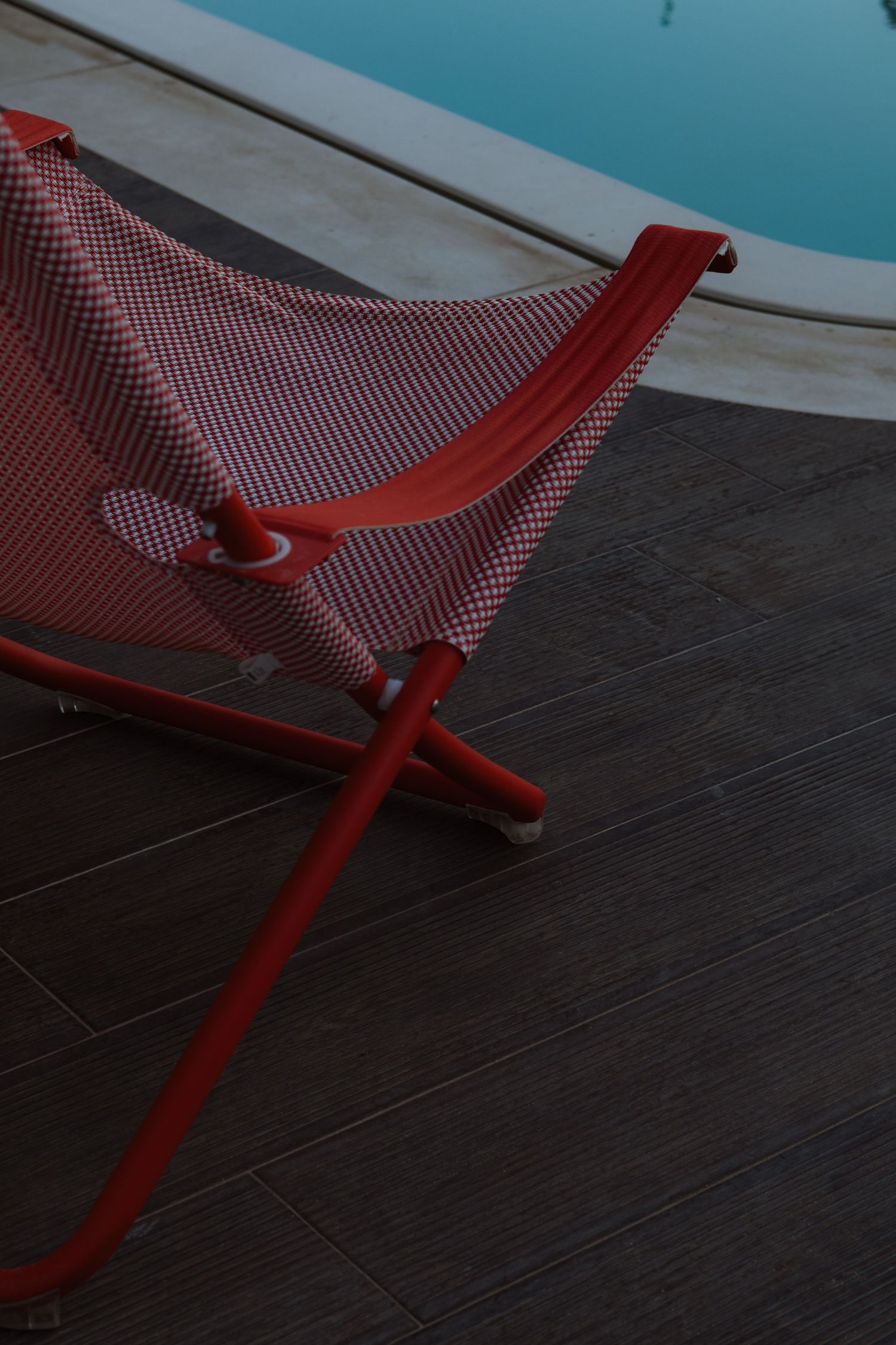 A sequence of modern red geometric bench designs against a light blue wall showing different angles and perspectives.