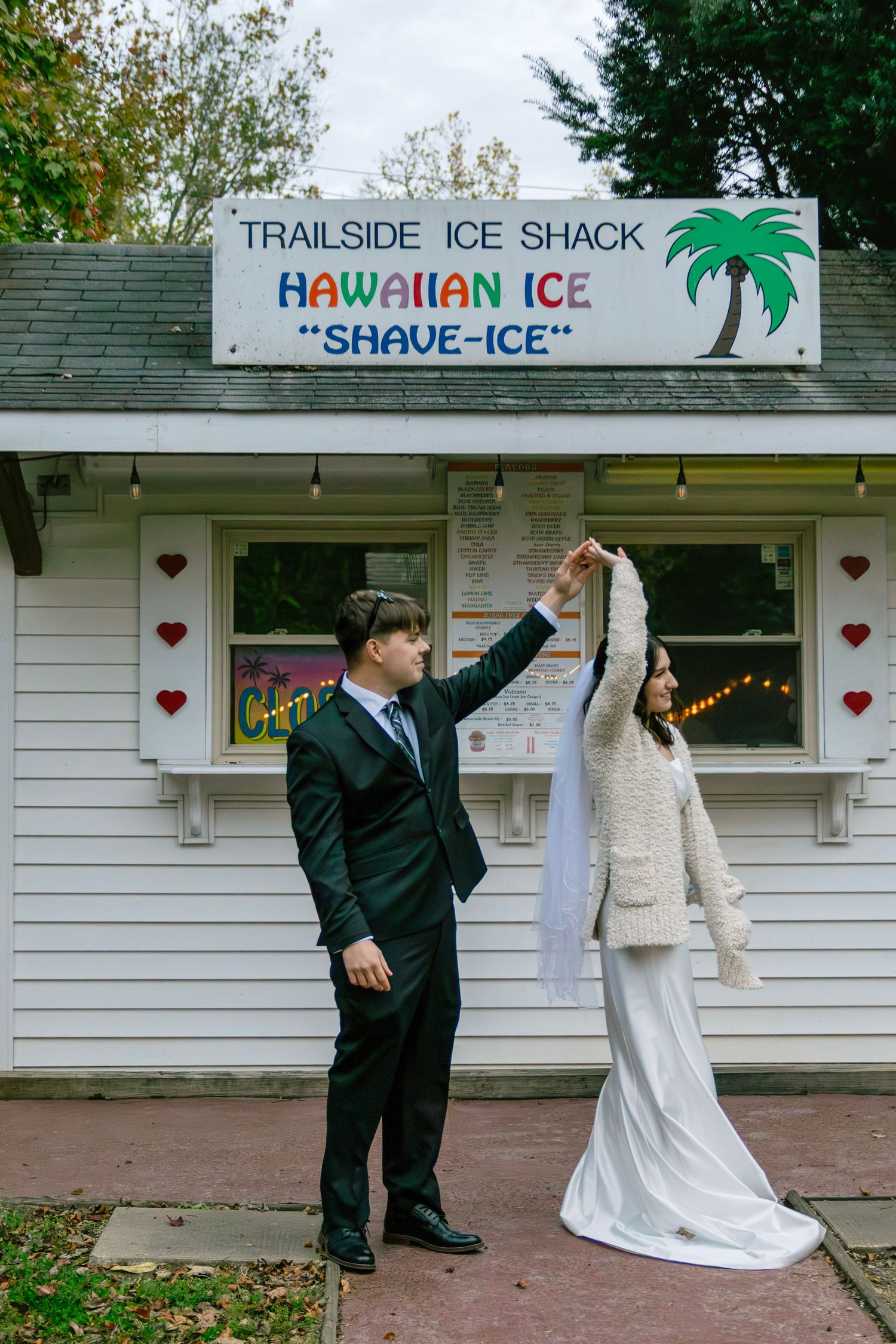 Bride and groom dance playfully outside Trailside Ice Shack Hawaiian shave ice stand on wedding day.