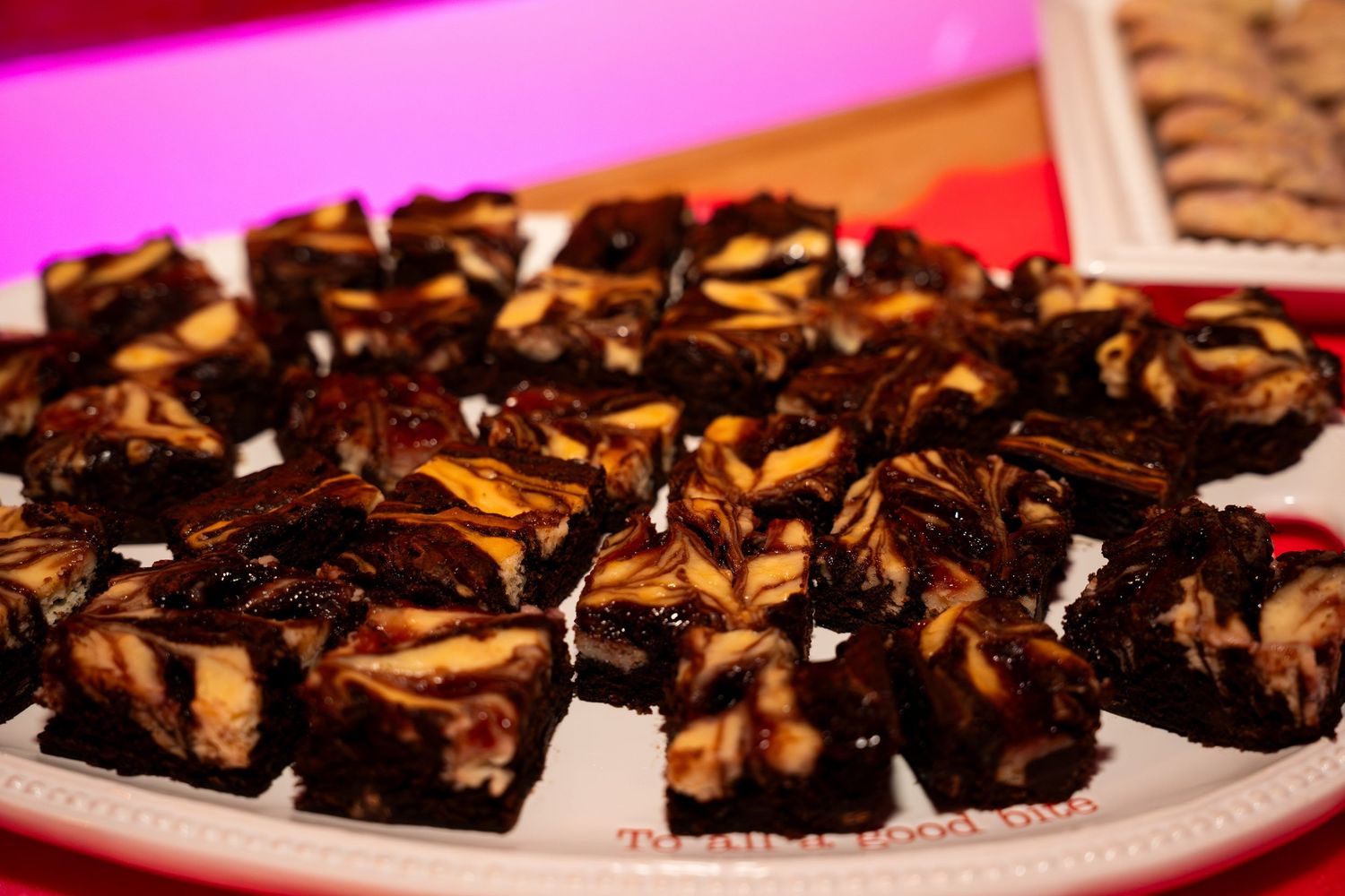 Plate of chocolate peanut butter swirl brownies cut into squares at party dessert table.