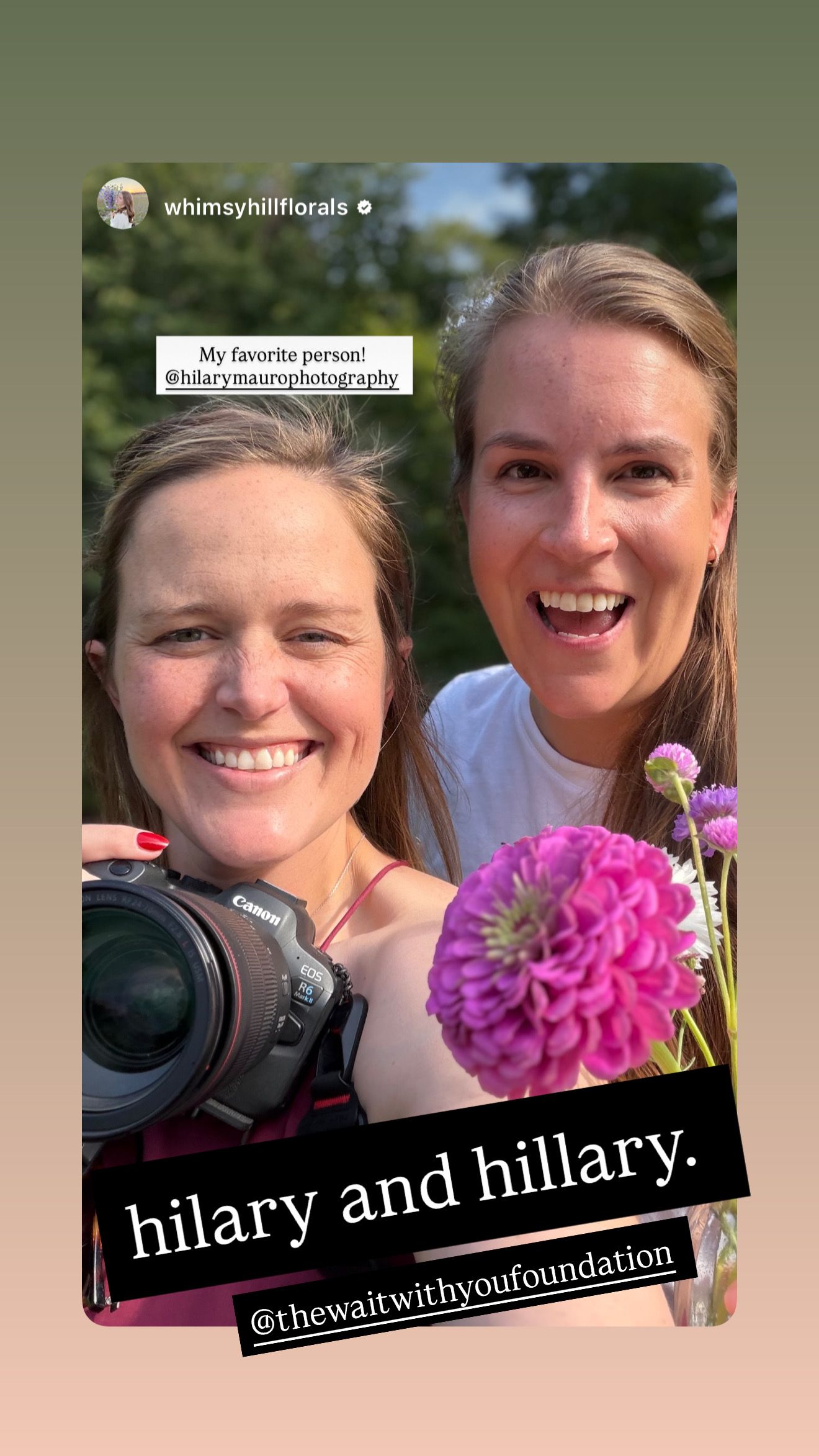 Two smiling women named Hilary and Hillary pose outdoors, one holding a Canon camera and pink zinnia flowers.