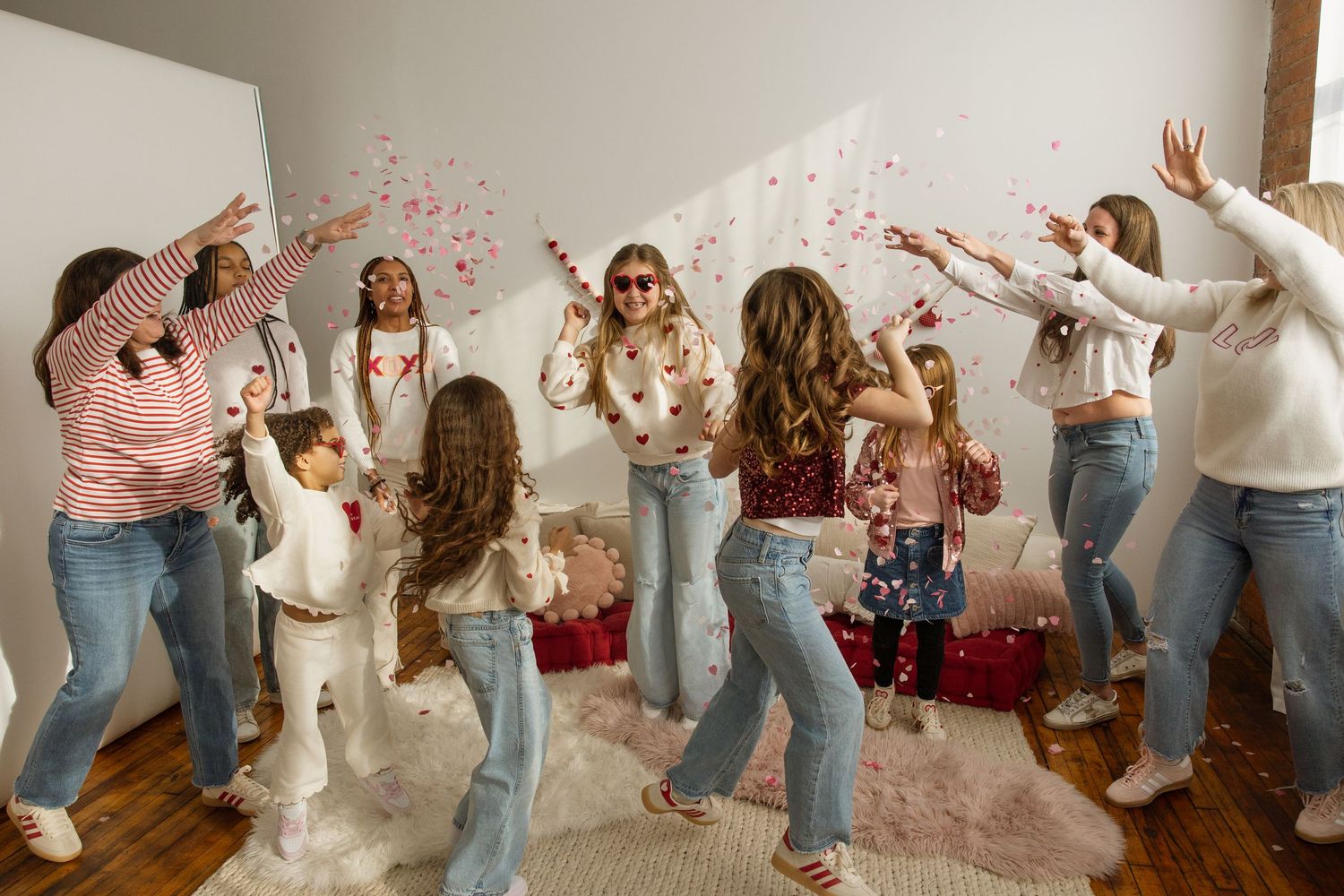 Group of girls dancing and throwing confetti at a Galentine's mini session.