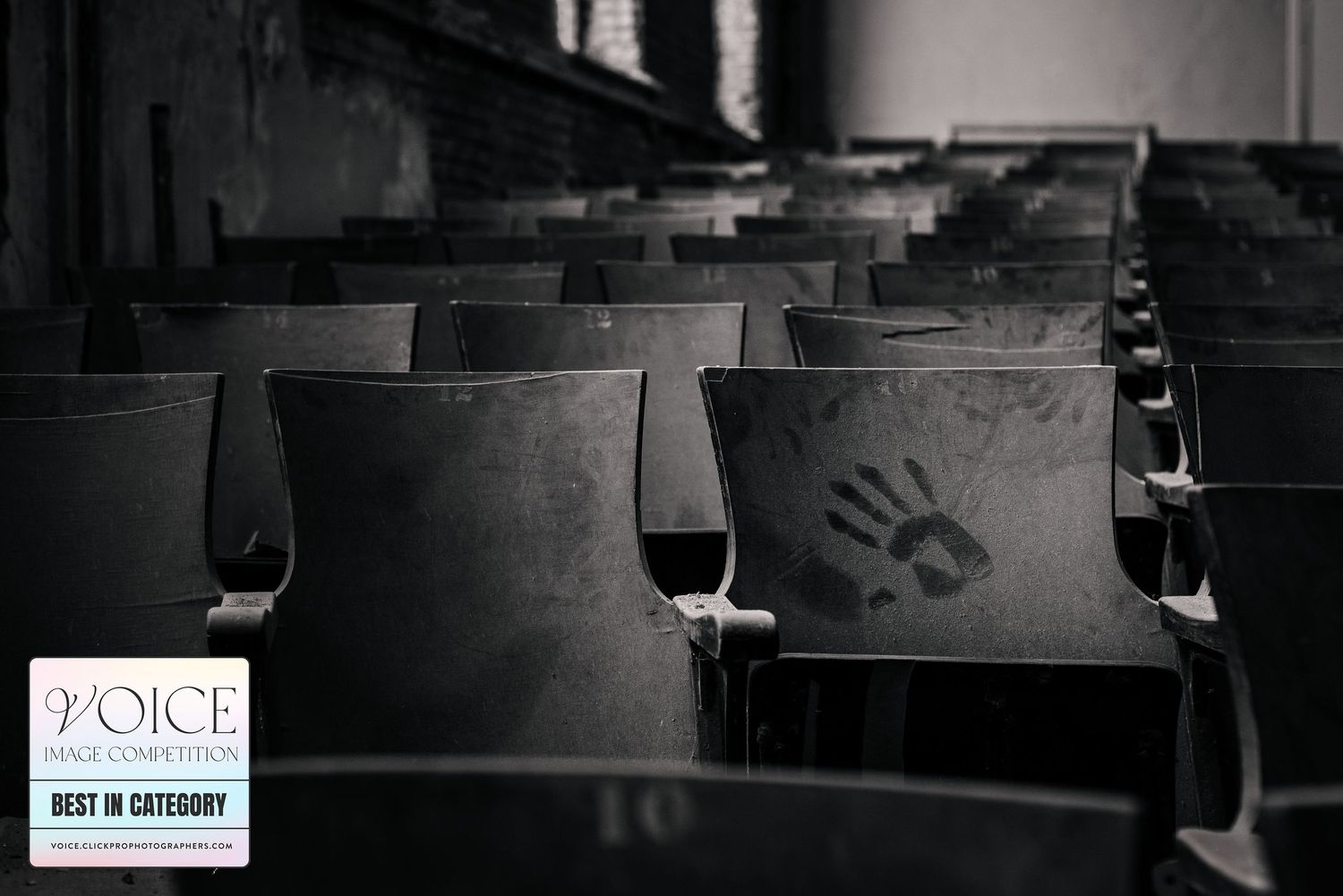A lone handprint on a seat in the JW Cooper School Auditorium. Best in category, Black and White, Voice competition 2023. Tracey Richvalsky