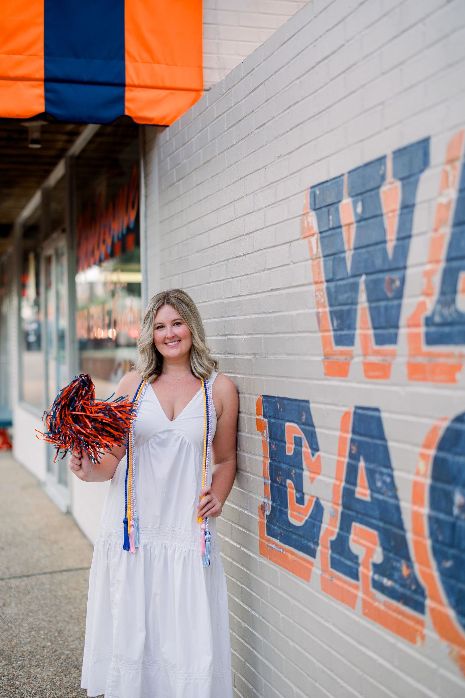 A series of photos showing someone in a white dress posing against a blue and orange painted wall.