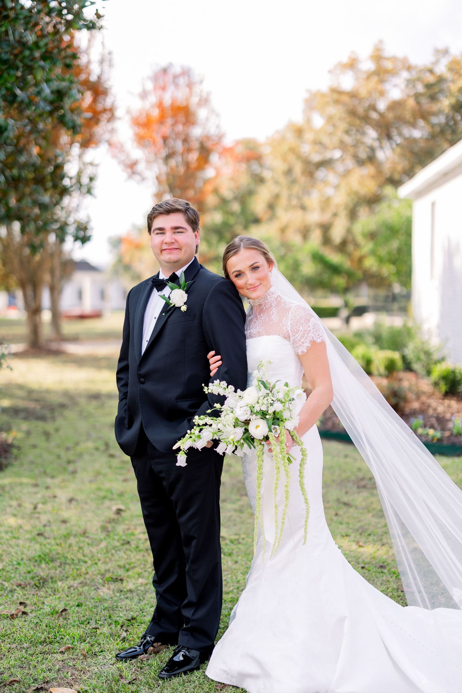 Wedding couple takes candid photos in outdoor garden with fall colors.