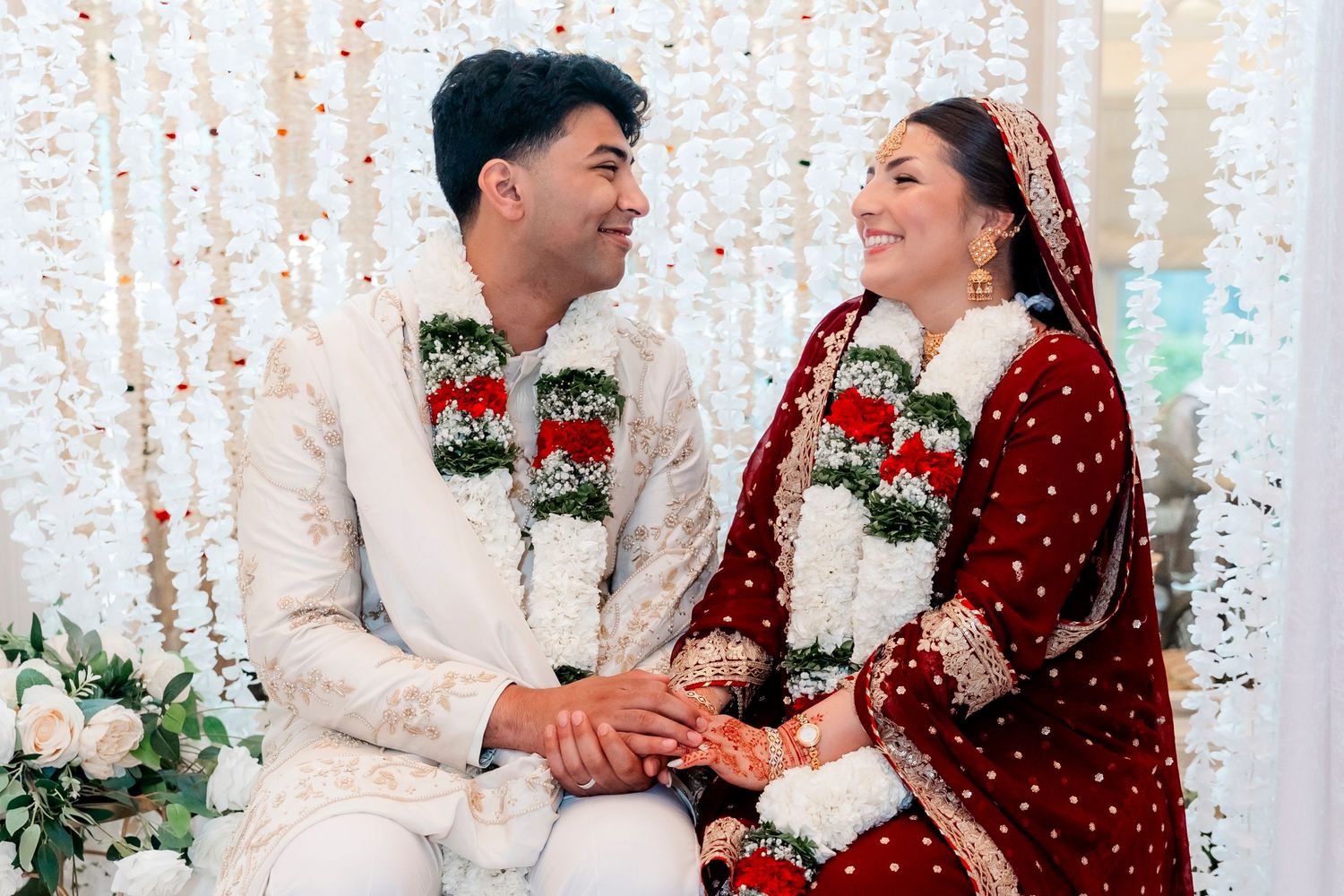 Holiday couple photos with string lights and festive red and white outfits.