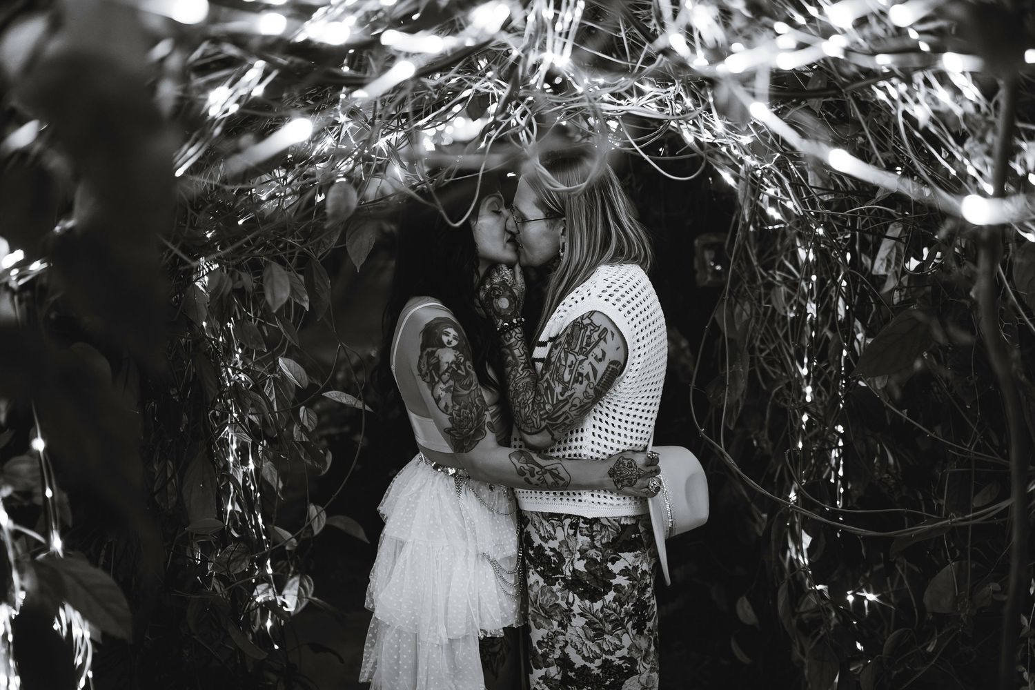 A couple shares an intimate moment during a black and white outdoor photoshoot in nature.