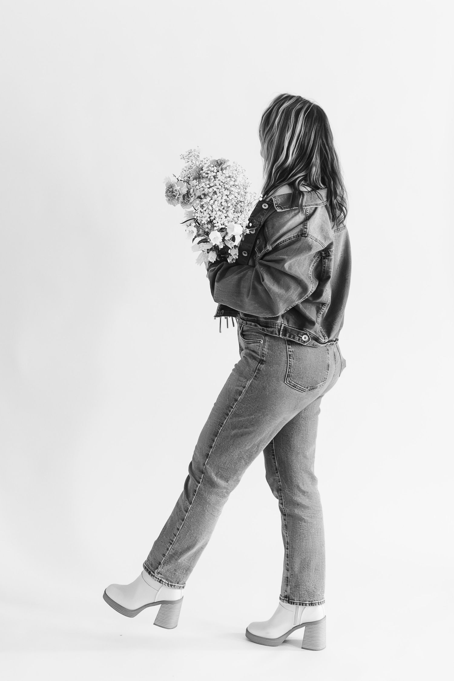 Black and white sequence of a small child in jeans holding flowers while walking, shown from behind in four progressive steps.
