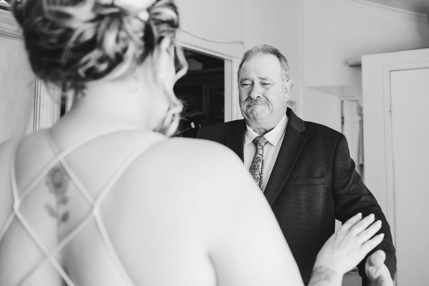 Black and white emotional moment captured during wedding preparation.