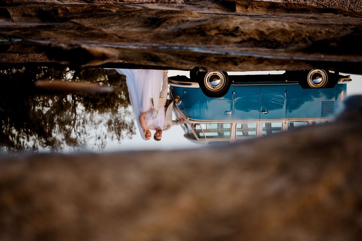 Creative upside-down reflection wedding photo in puddle with vintage car.