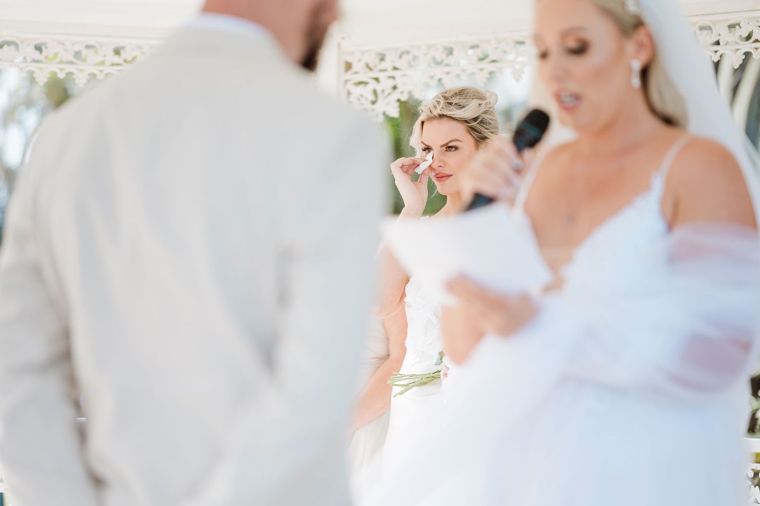 Soft focus wedding ceremony scene with white floral decorations.