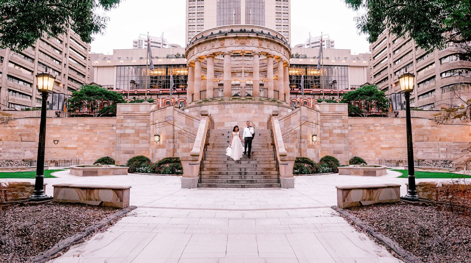 Historic stone building with grand staircase and wedding ceremony setup.