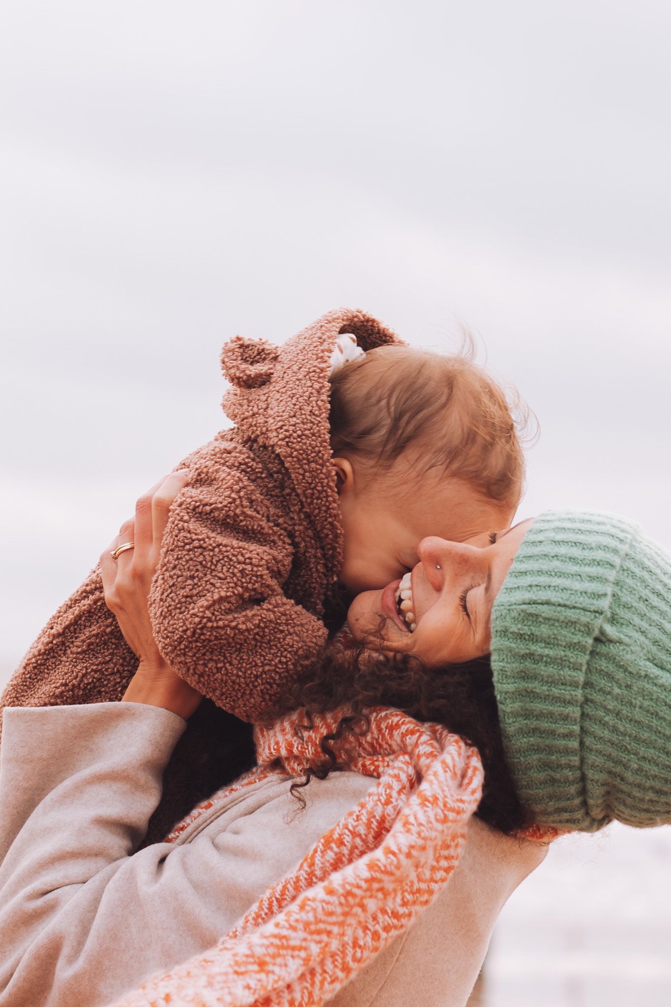mother holding baby during family portrait session on a beach in Kent