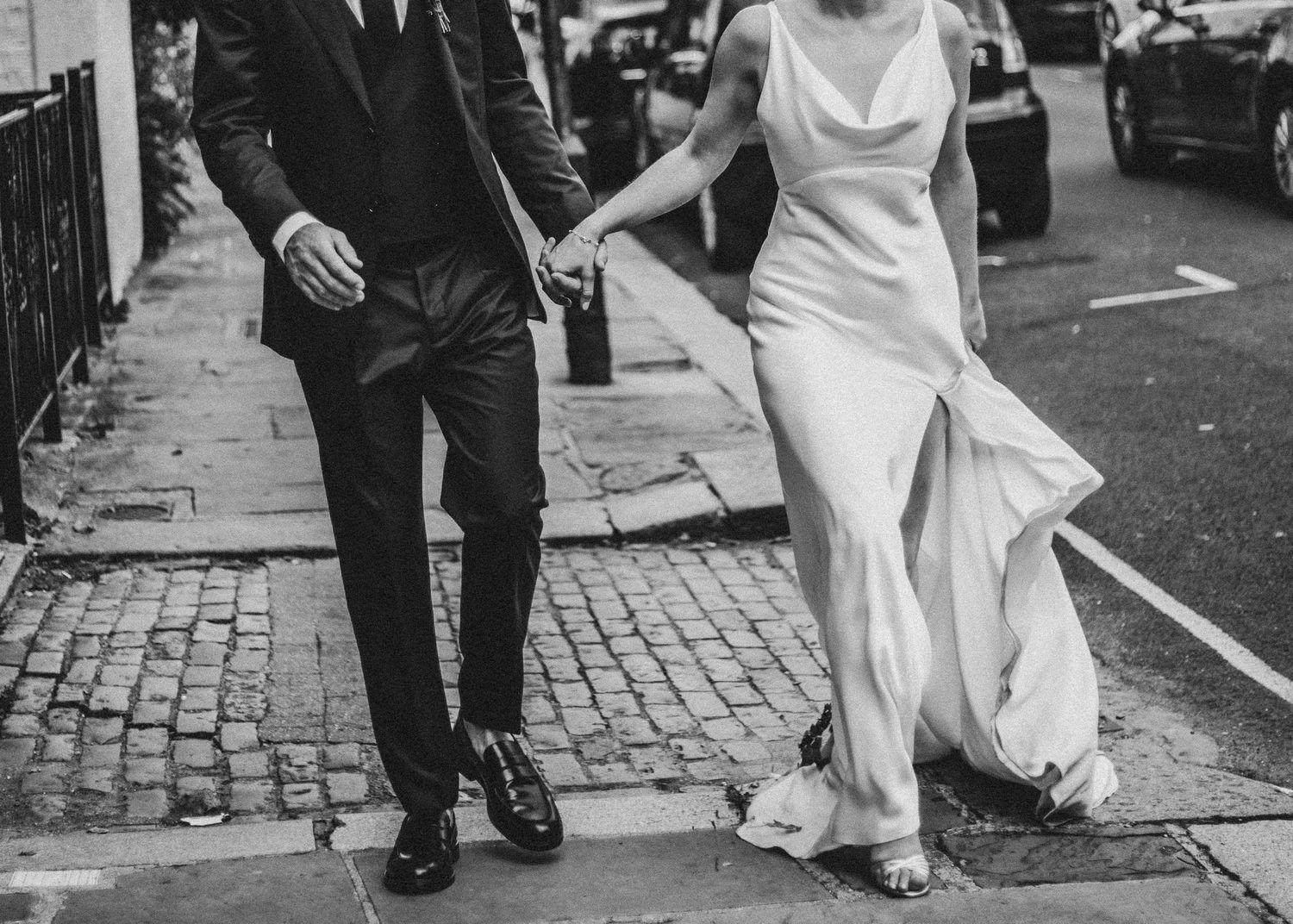 bride and groom holding hands as they walk down a London street by Dominique Lauren Photography