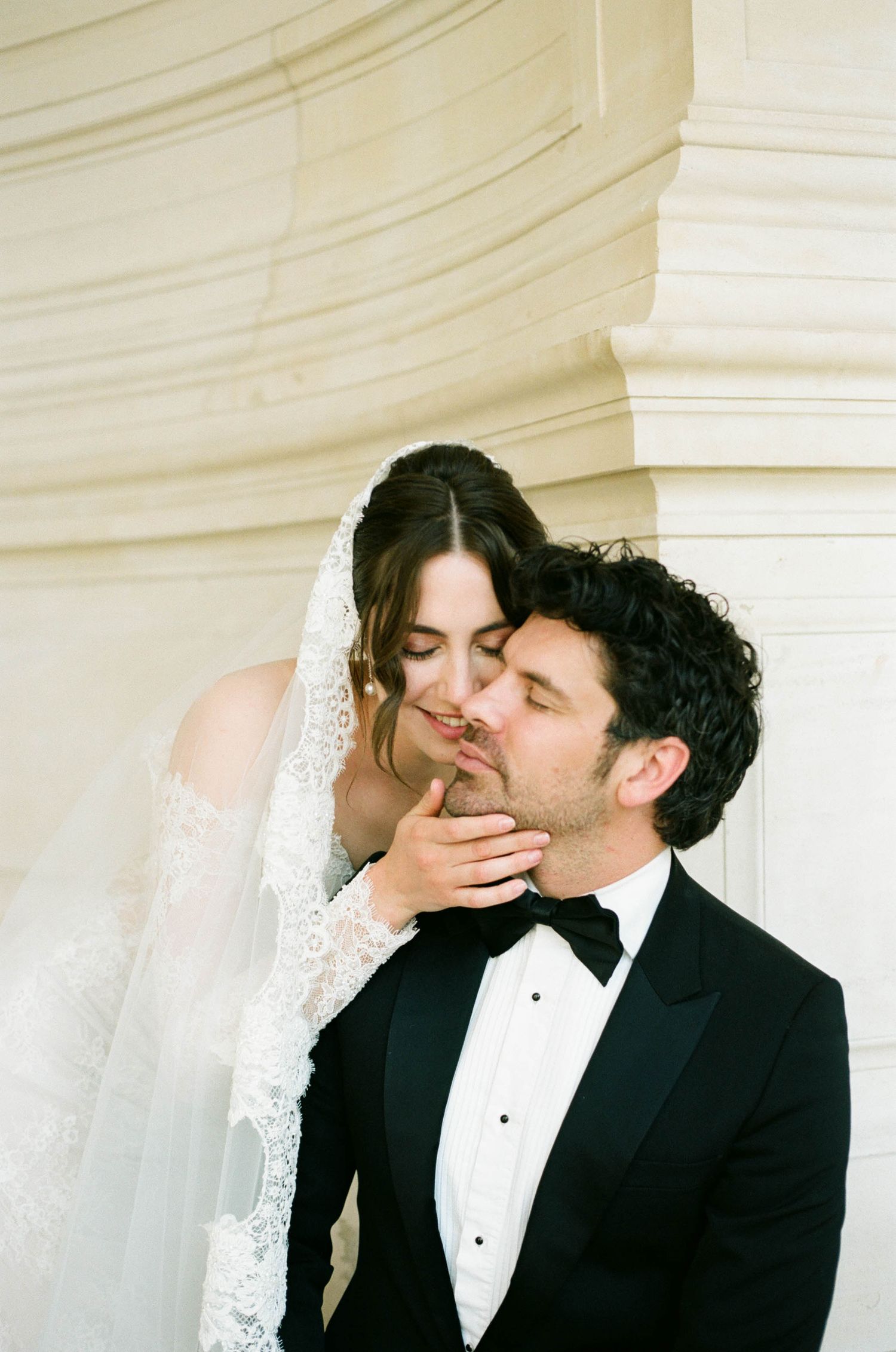 Romantic wedding moment captured in a sequence showing bride and groom sharing tender kisses against a white backdrop.