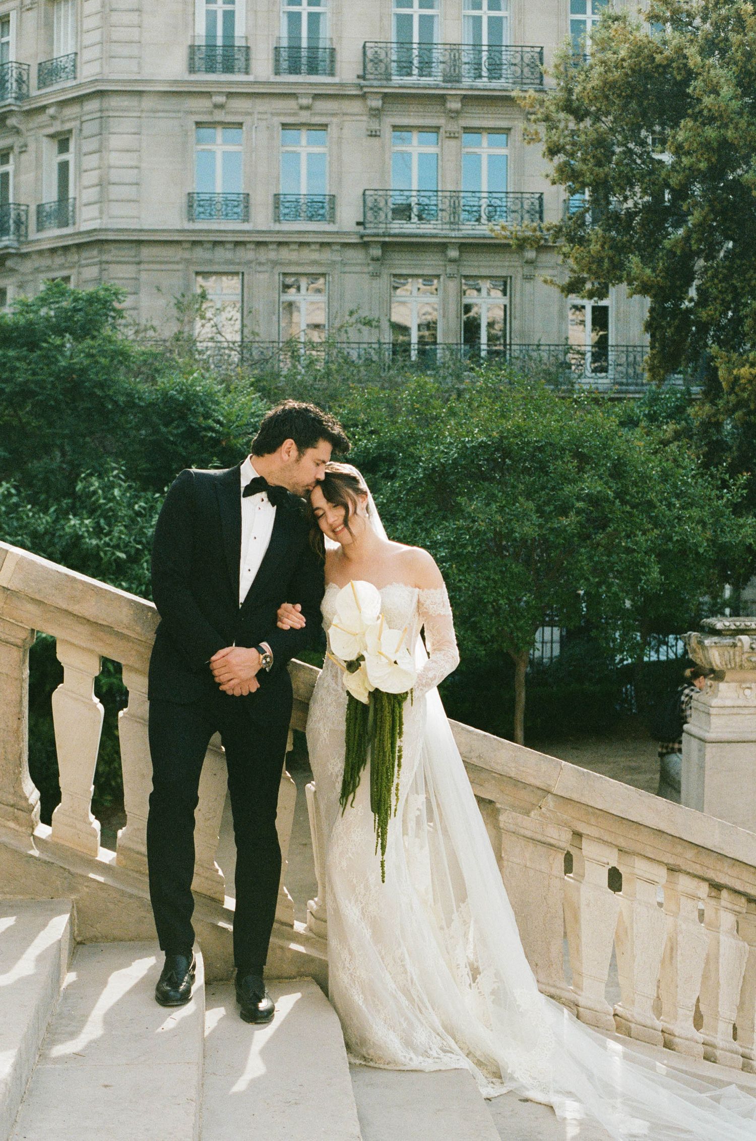 A romantic wedding photo sequence of four shots showing a couple against a classic stone balcony and Parisian architecture.