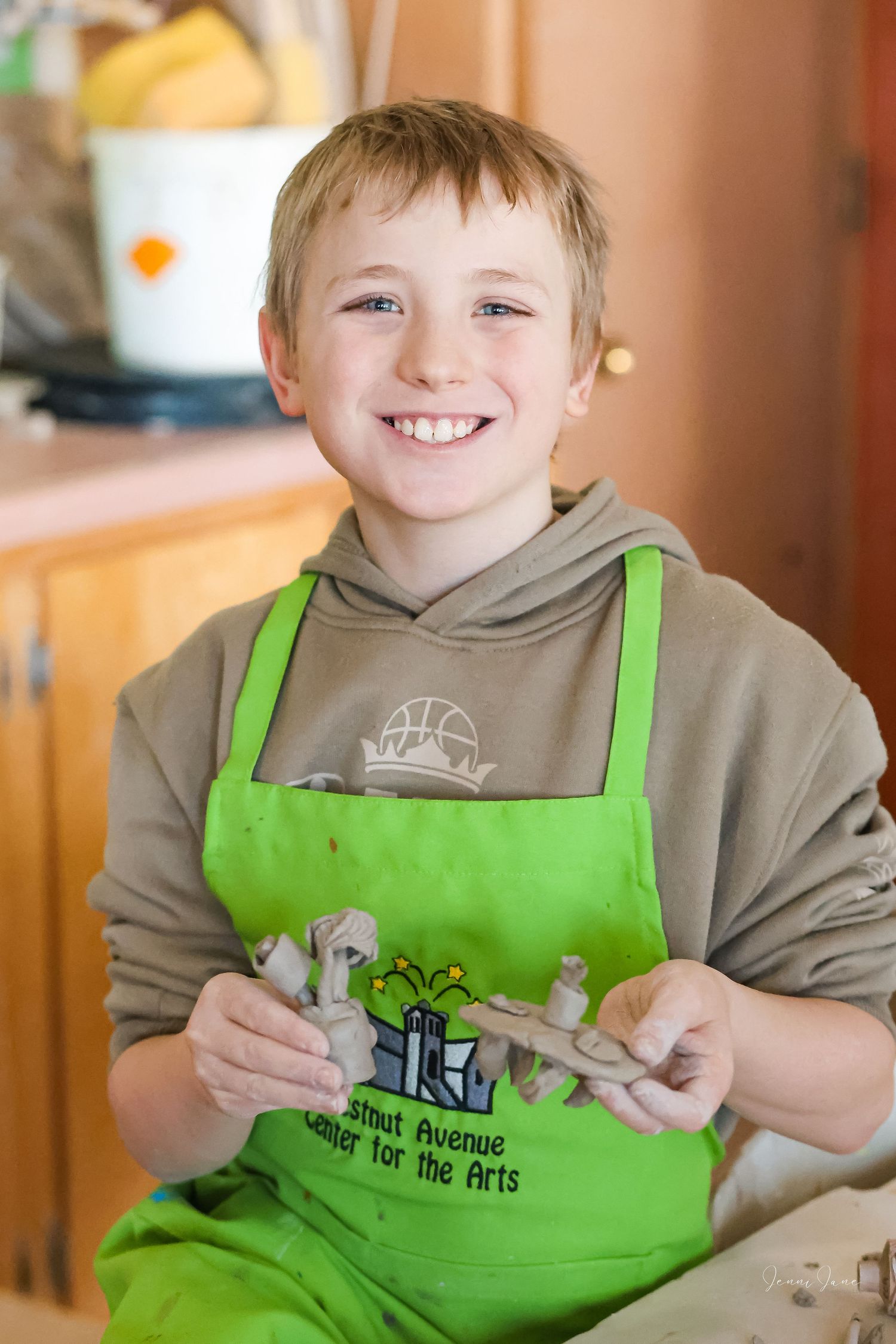 A sequence of photos showing someone wearing a bright green apron and gray hoodie while participating in a cooking activity.