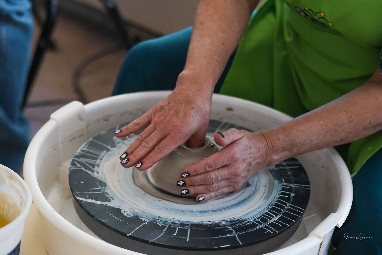 Hands working clay on a pottery wheel in sequential steps showing the ceramic making process.