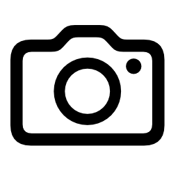 Black outline camera icon with circular lens and small viewfinder dot on white background.