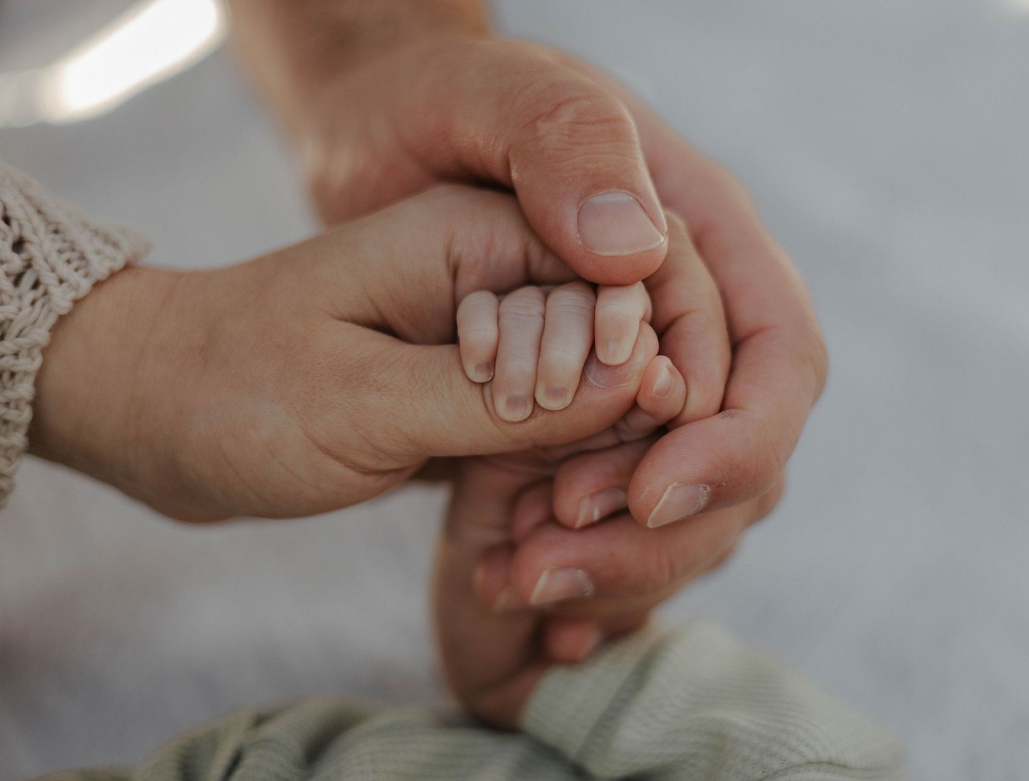 Close-up of hands clasped together in a tender moment.