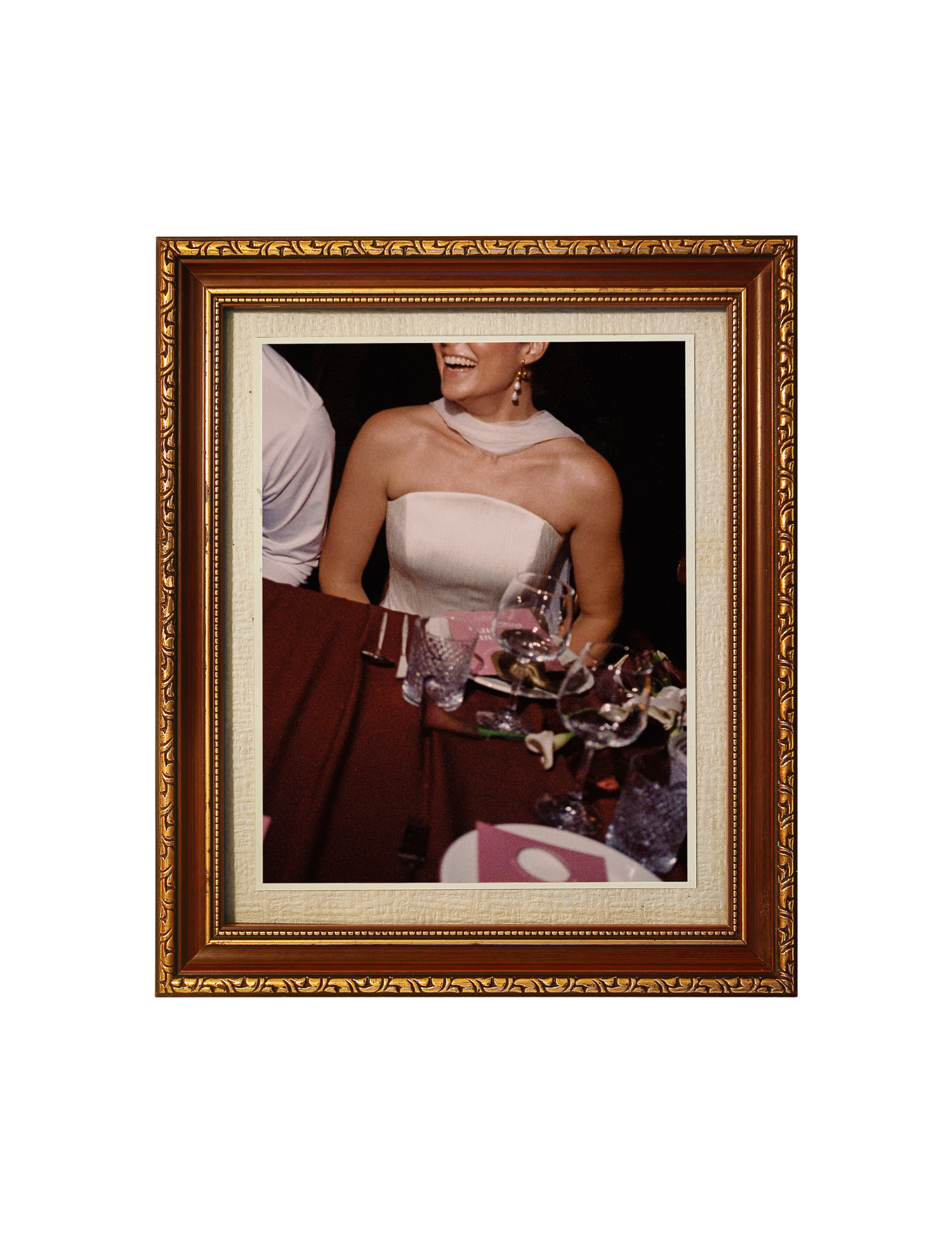 Ornate gold-framed photo of an elegant woman in a white strapless dress holding a tray at a formal event.