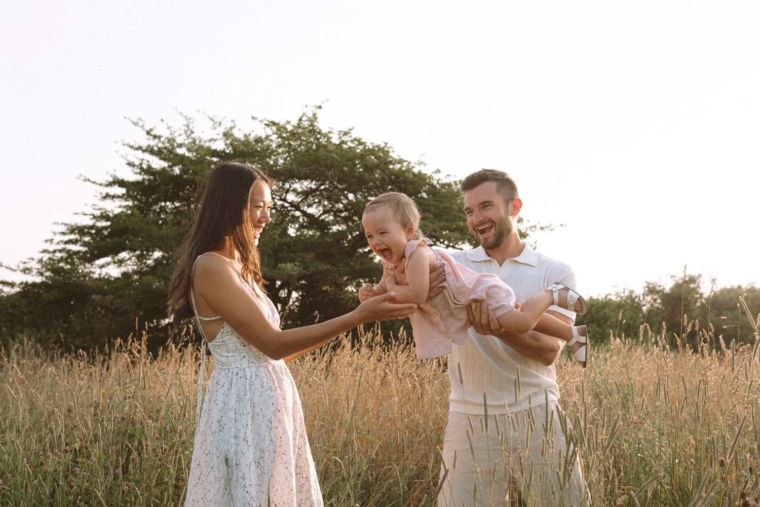 Family sharing playful moment together in golden hour light.