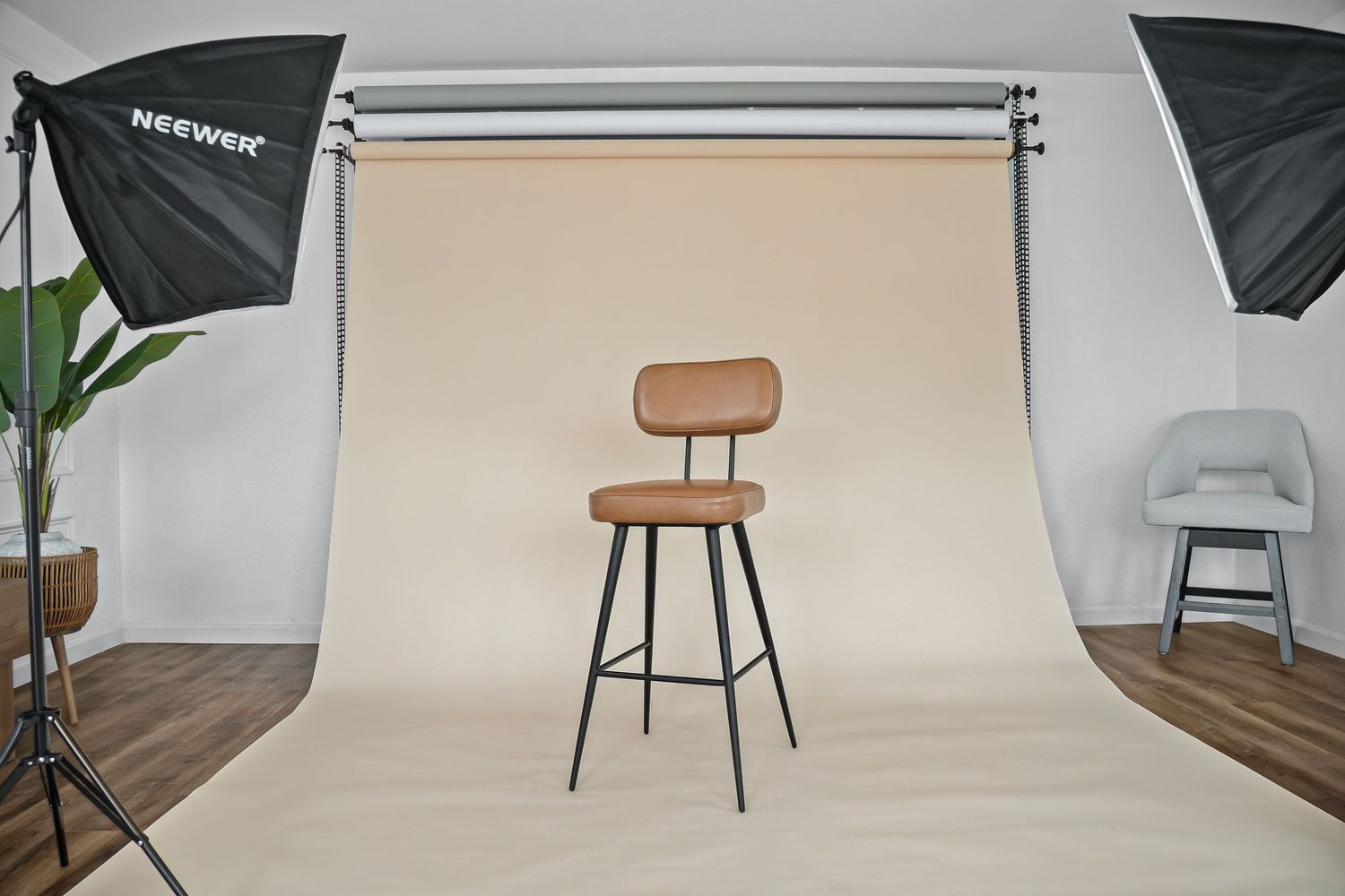 Brown leather swivel bar stool with black metal frame in professional studio with softbox lighting.