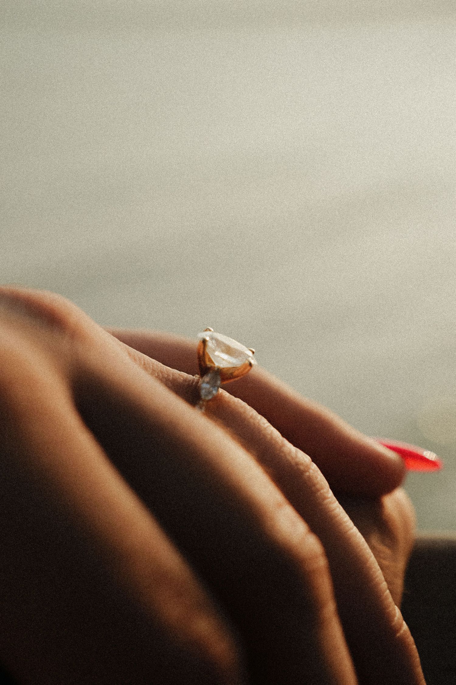 Close-up of elegant teardrop diamond engagement ring on woman's hand.