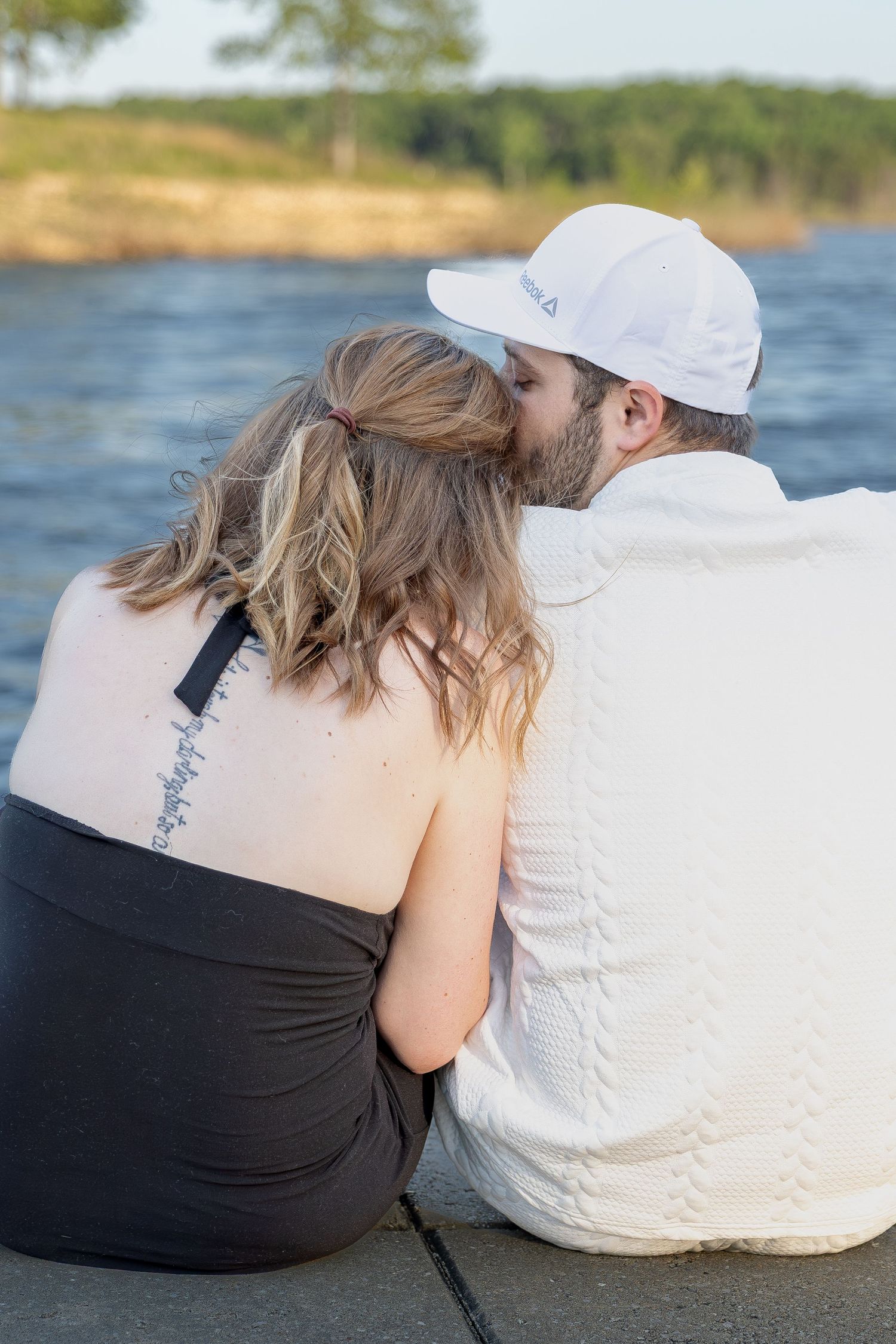 Engaged couple sharing romantic moments during an outdoor engagement session with natural posing, genuine smiles, and golden-hour light.