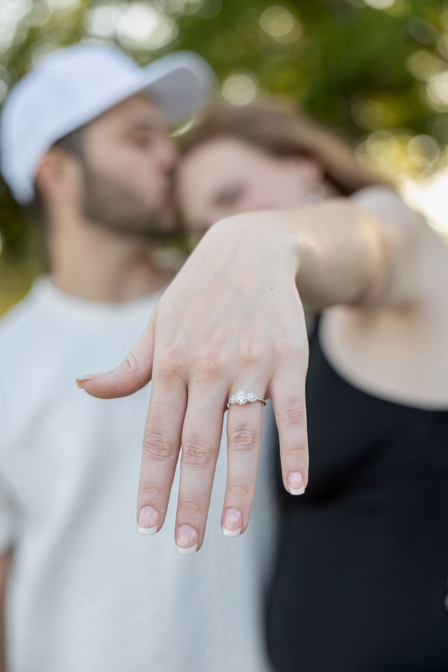 Engaged couple sharing romantic moments during an outdoor engagement session with natural posing, genuine smiles, and golden-hour light.