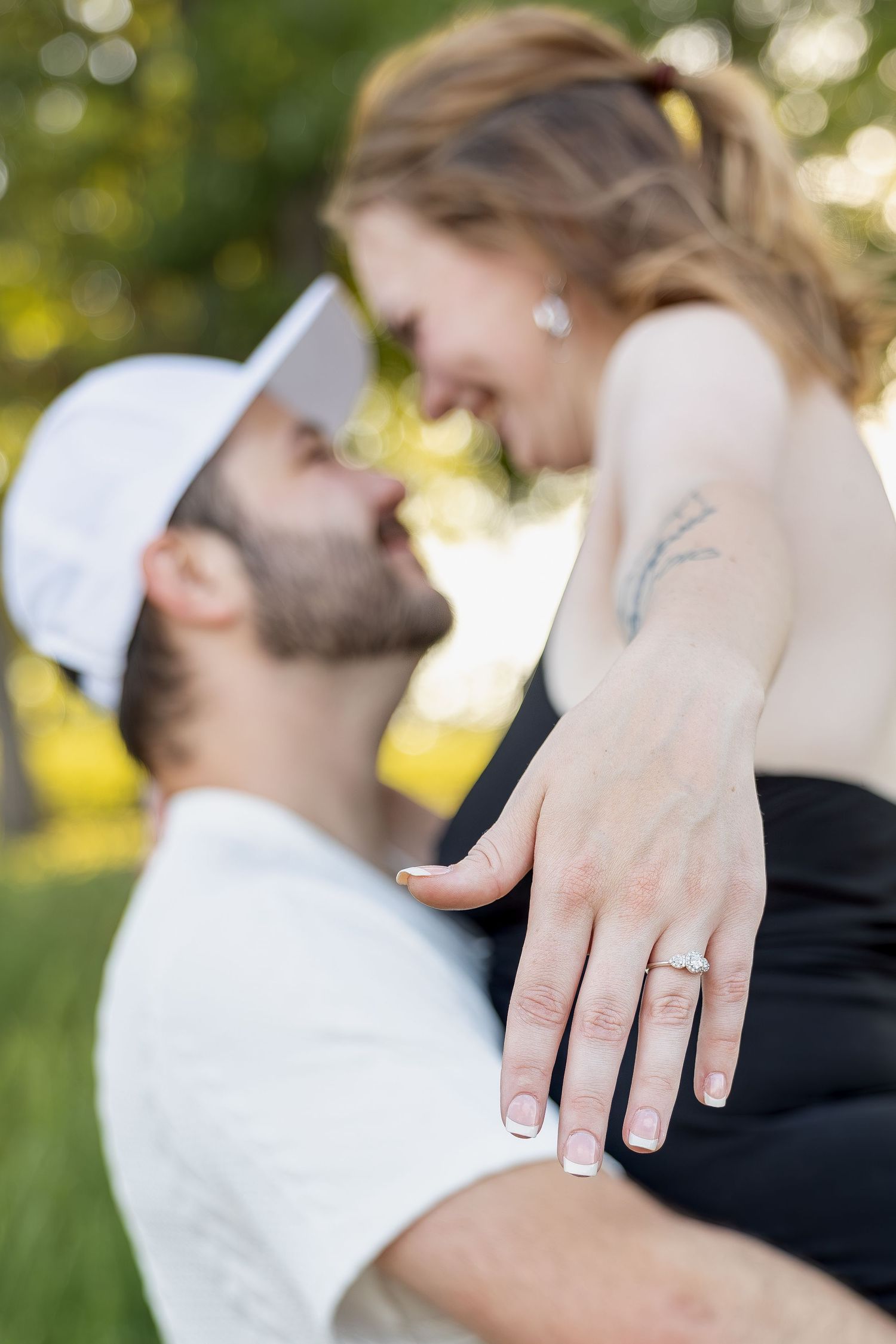 Engaged couple sharing romantic moments during an outdoor engagement session with natural posing, genuine smiles, and golden-hour light.